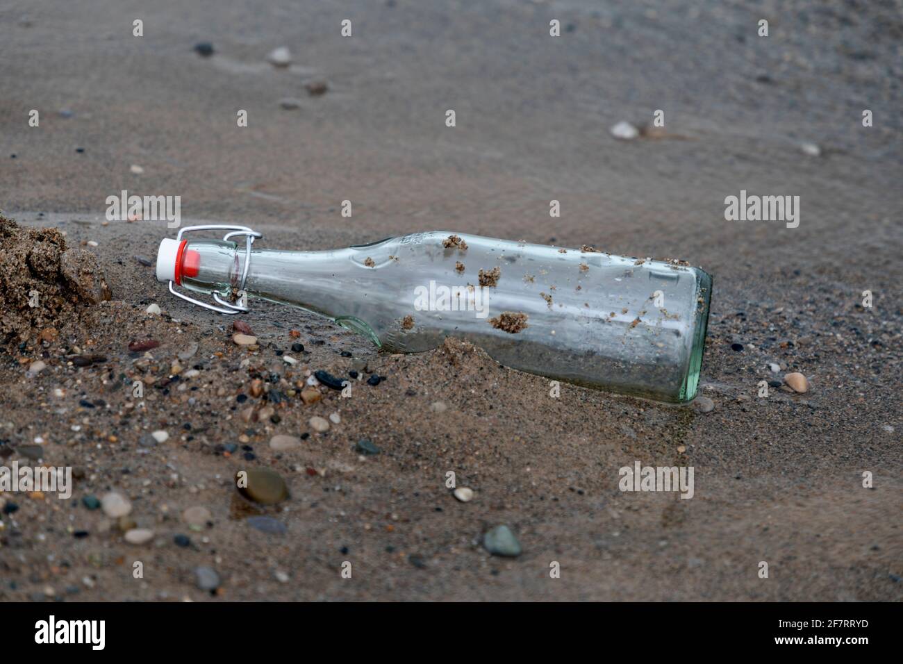 Glasflasche am Sandstrand, Stockfoto
