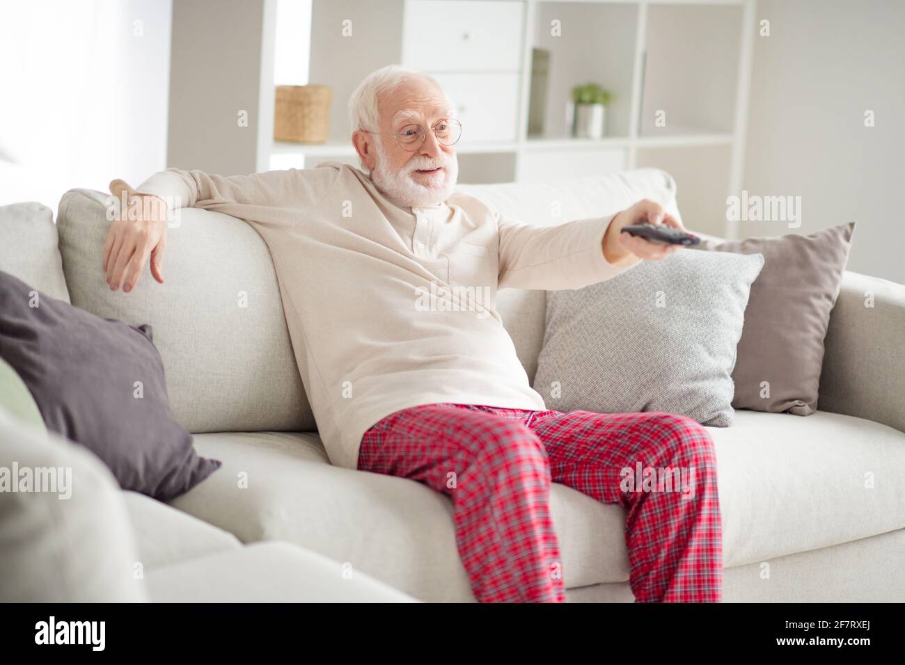 foto-von-alteren-mann-rentner-sitzen-couch-home-rest-entspannen-schauen-sie-sich-die-fernbedienung-fur-den-kanalwechsel-im-kino-an-2f7rxej.jpg