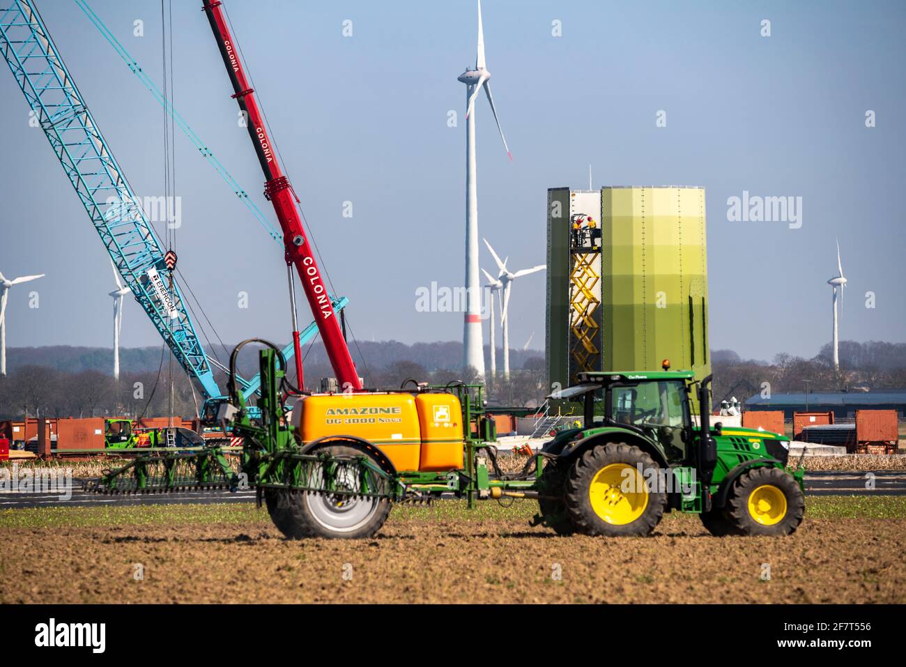 Bau einer Windkraftanlage, Stahlsäule von Enercon, bei Kerken, Kreis Kleve, am Niederrhein, Landwirt bringt Pflanzenschutzmittel hervor Stockfoto