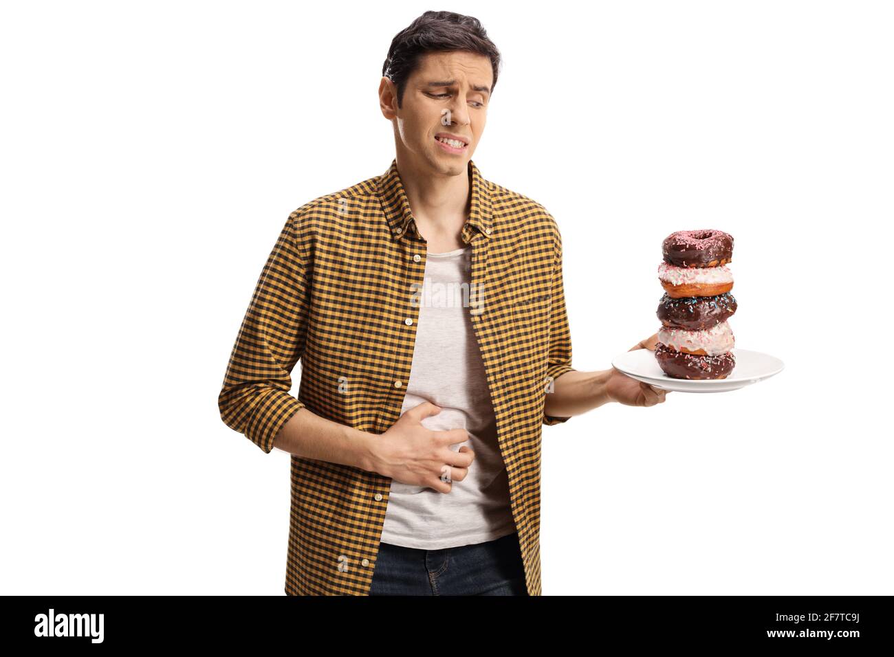 Junger Mann mit Magenschmerzen, der einen Teller hält Donuts isoliert auf weißem Hintergrund Stockfoto