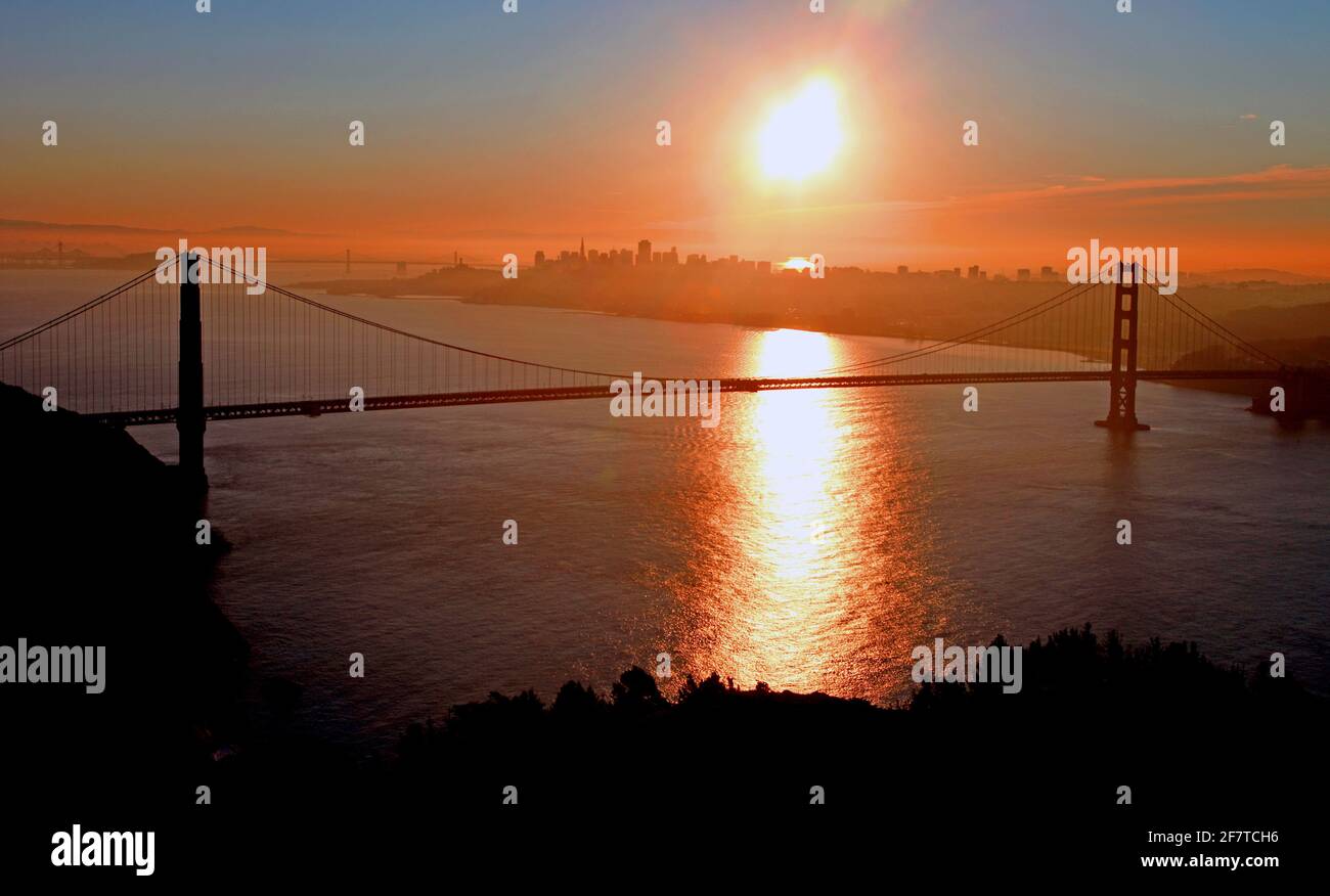 Panoramablick auf die Bucht von San francisco mit der Golden Gate Bridge im Vordergrund und dem Wasser und der Skyline der Stadt, die den strahlenden Morgen unterstützt. Stockfoto