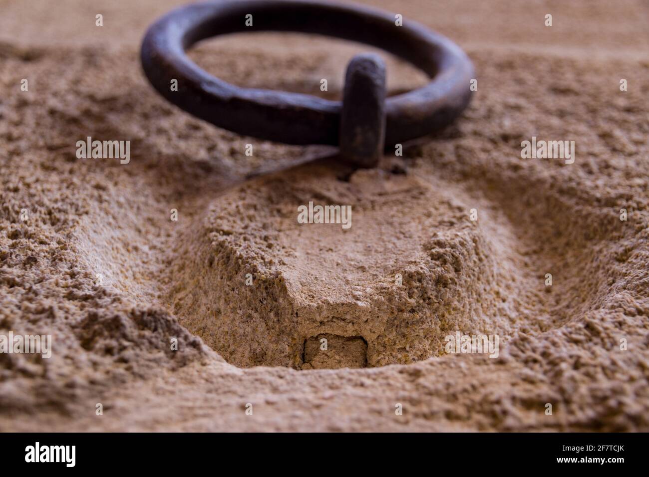 Detail eines alten rostigen Eisenrings, der an einem hängt Steinmauer Stockfoto