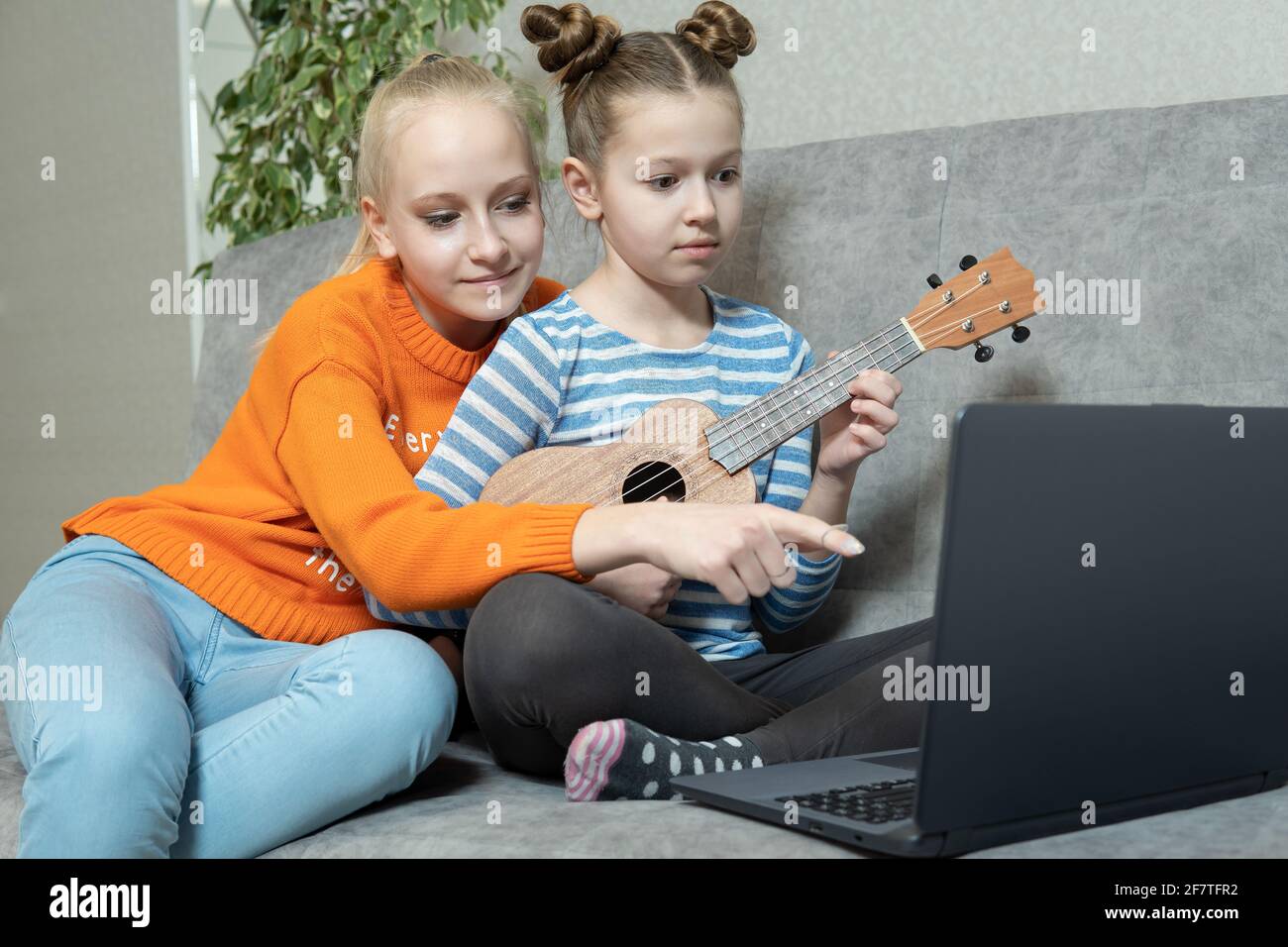 Kreative Teenager befreundet sich mit Musikinstrumenten, Akustikgitarre und Ukulele. Stockfoto