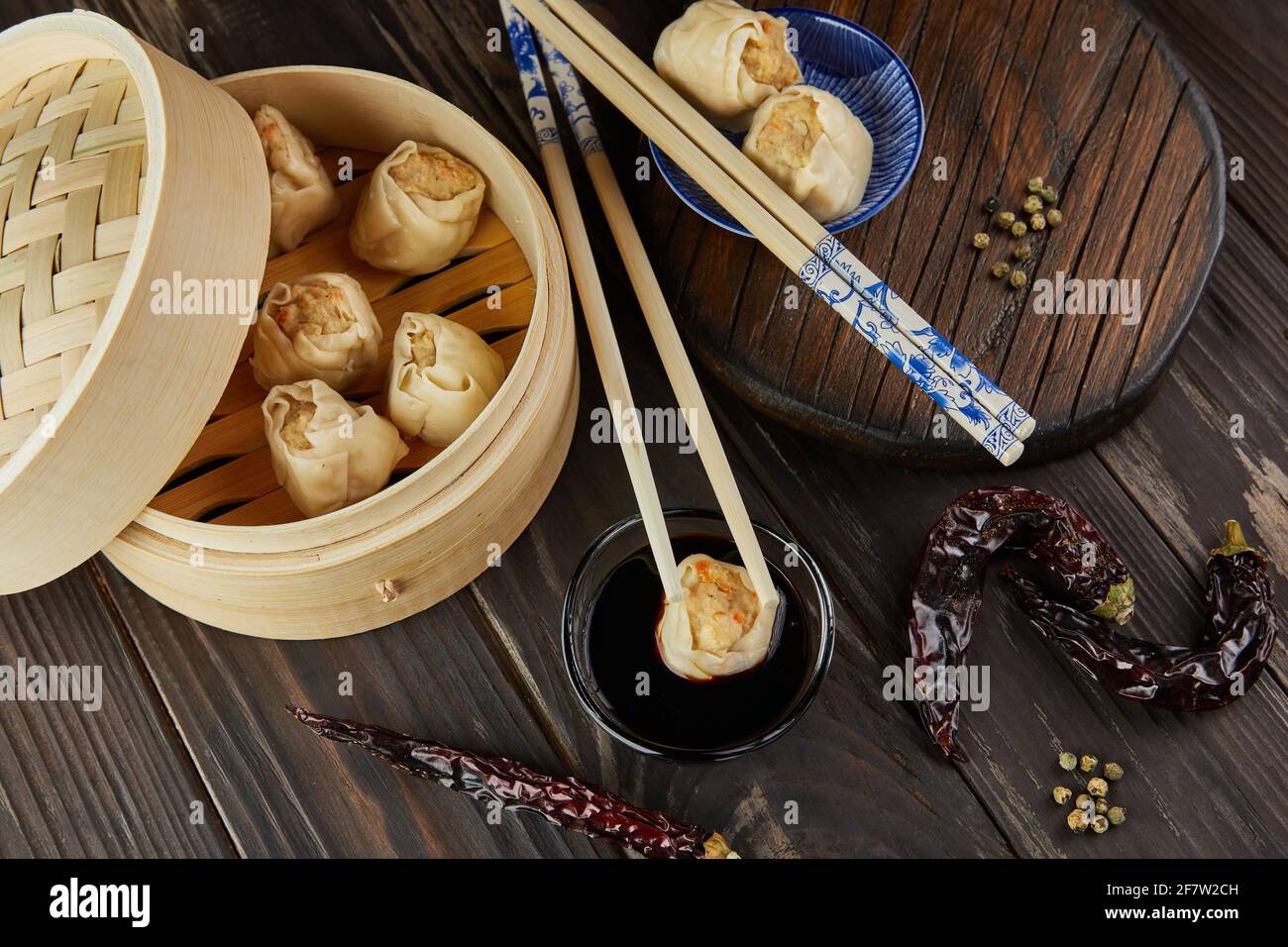 Shumai Shaomai Chinesisches Fleischknödel gedünstetes Gericht in Bambus-Dampfgarer-Box. Essstäbchen und Dimmen. Stockfoto