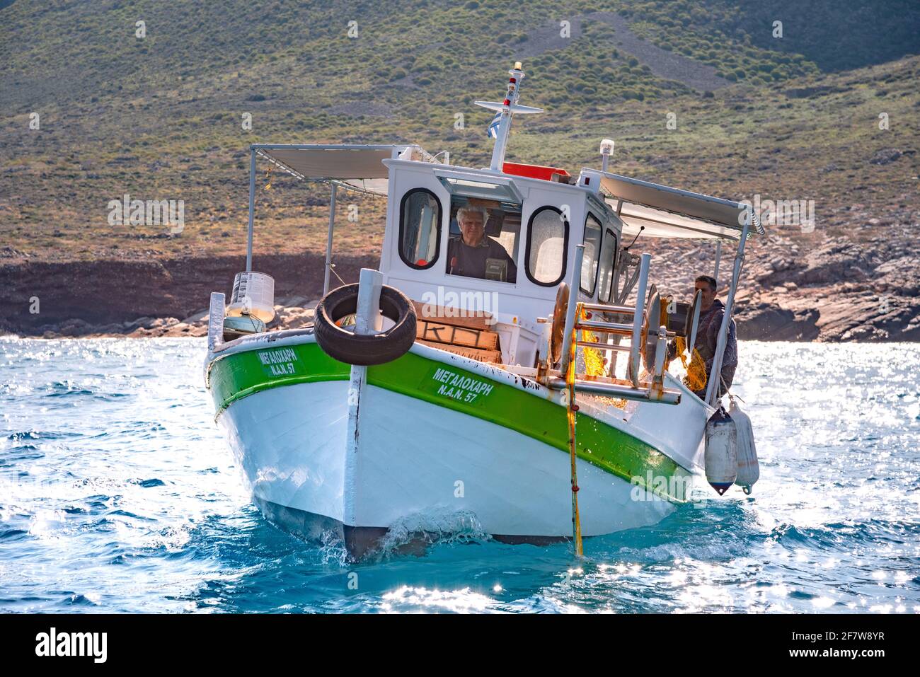 Fisherman fischt frische Fische mit gelben Fischernetzen auf einem Fischerboot, Kreta, Griechenland Stockfoto