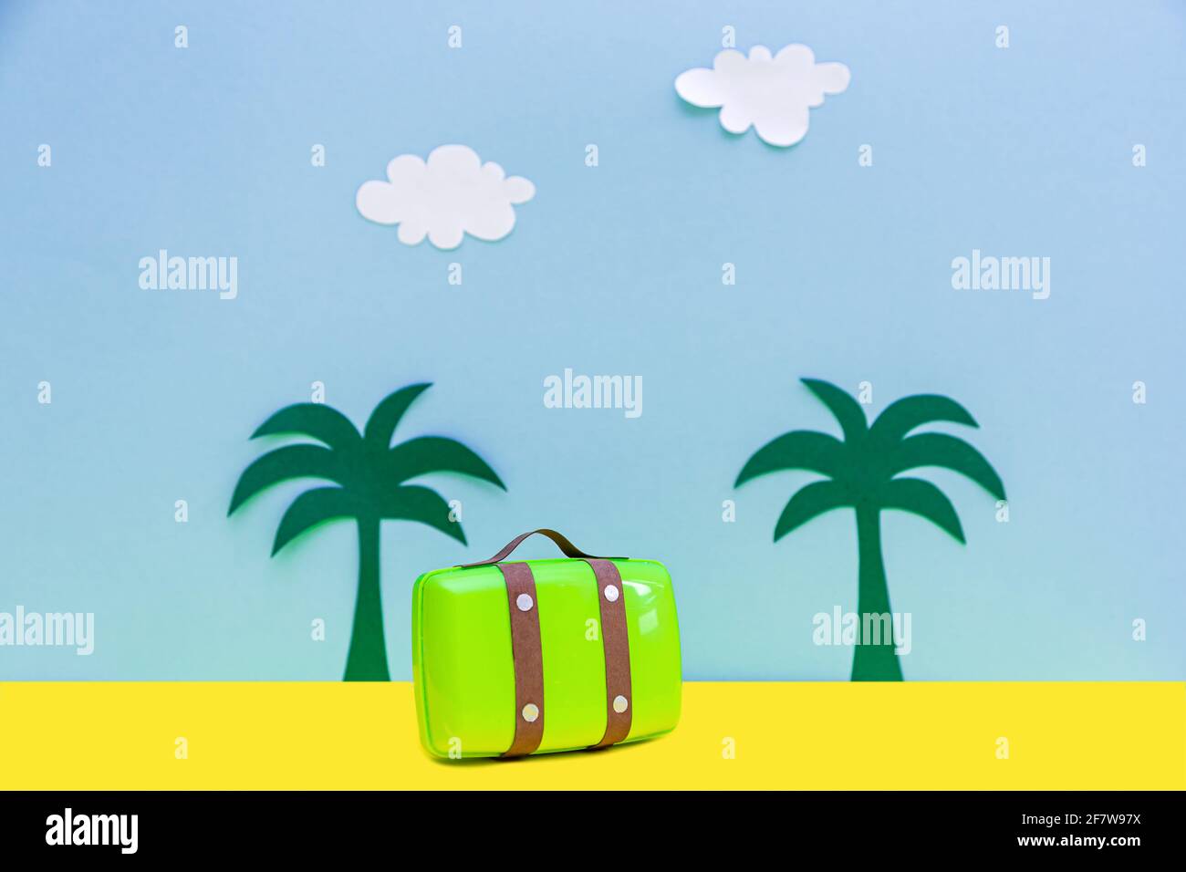 Blaue und gelbe Hintergründe mit Wolken, Handflächen und Gepäck. Aus farbigem Papier geschnitten. Reisekonzept. Stockfoto