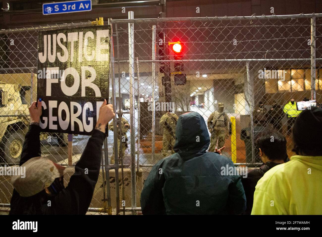 Minneapolis, Minnesota, USA. April 2021. 9. April 2021-Minneapolis, Minnesota, USA: Ein Demonstrator hält ein Zeichen, das ''Gerechtigkeit für George''' zur Ansicht der nationalen Wachleute sagt, die das Hennepin County Government Center bei einem marsch in Downtown Minneapolis gegen Polizeibrutalität inmitten VON DEREK CHAUVINS Prozess bewachen. Quelle: Henry Pan/ZUMA Wire/Alamy Live News Stockfoto