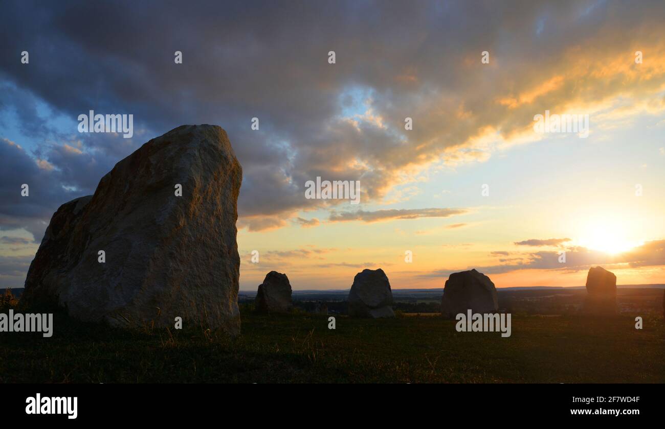 Uralte Steinmenhire auf der Wiese im Sonnenuntergang. Stockfoto