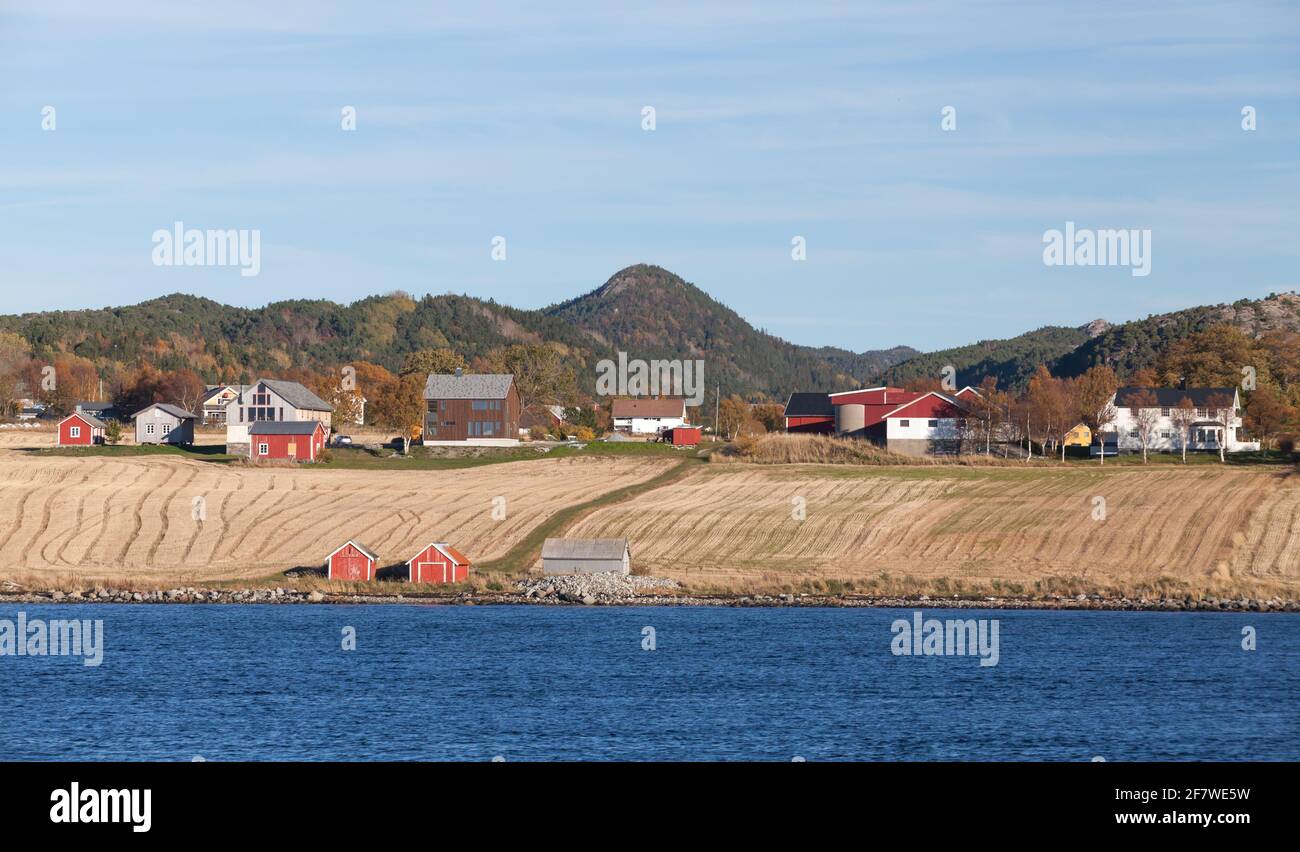 Norwegisches Dorf mit Holzhäusern an der felsigen Küste an Herbstmorgen Stockfoto