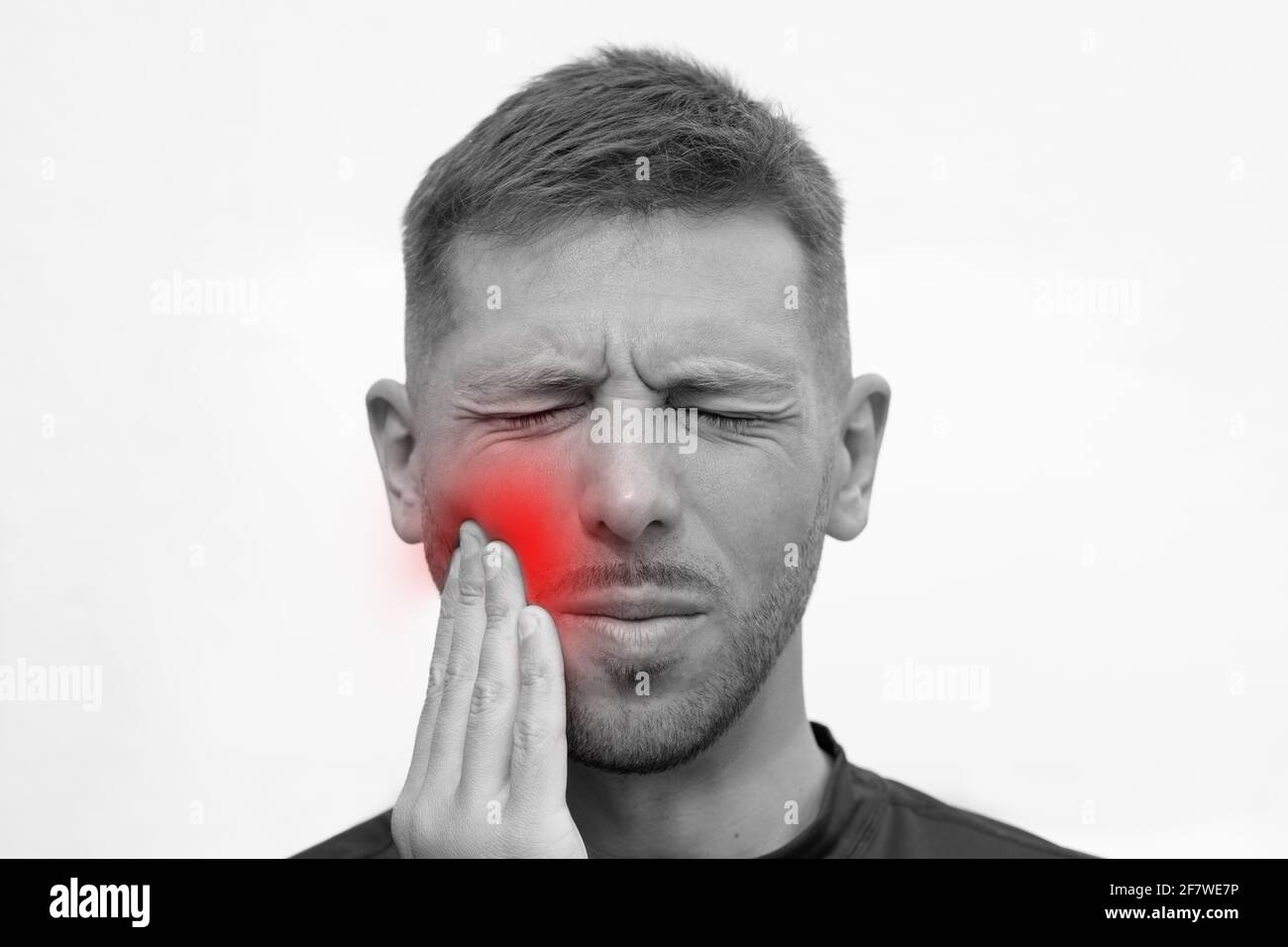 Nahaufnahme des menschlichen Gesichts mit starken Zahnschmerzen. Mann, der an Zahnschmerzen leidet oder Zahnschmerzen empspürt Stockfoto