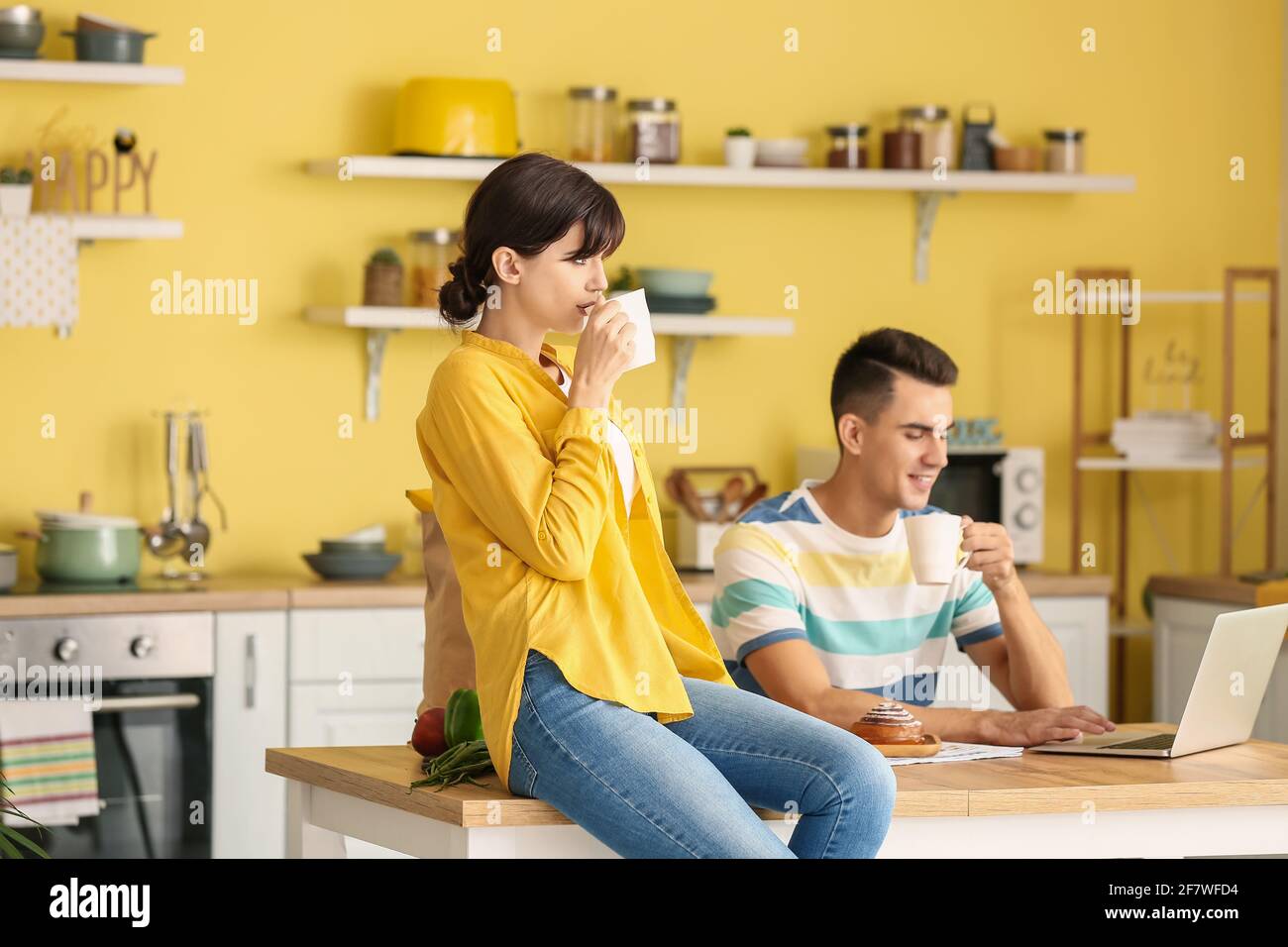 Glückliches junges Paar mit Laptop auf der Suche nach neuen Rezept in Küche Stockfoto