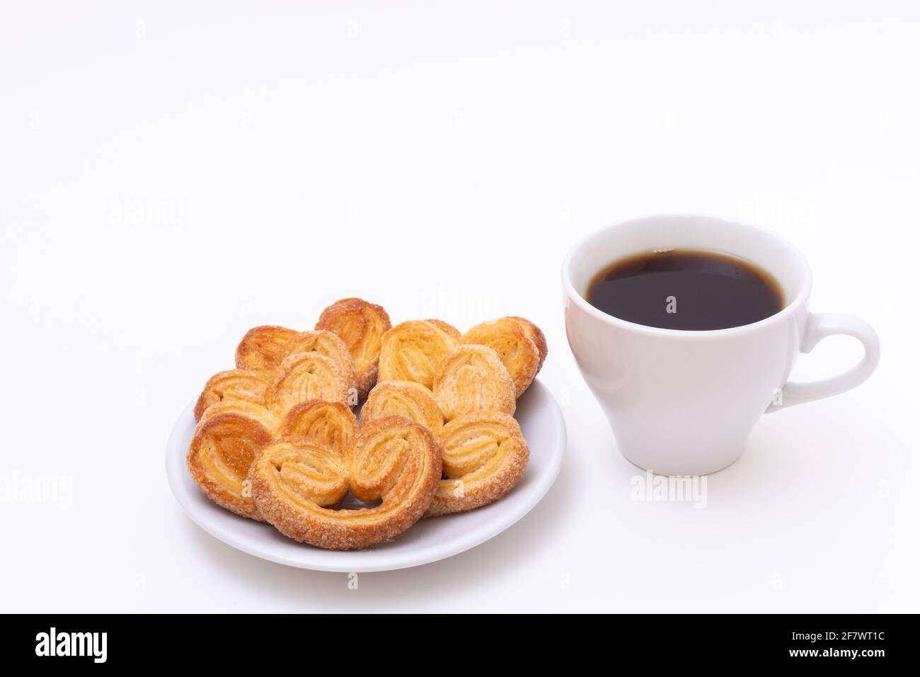 Weiße Tasse heißen schwarzen Kaffee oder heißer Schokolade und frisch gekochte herzförmige Kekse auf weißem Hintergrund, Platz zum Kopieren. Frühstück am Morgen für uns geliebt Stockfoto
