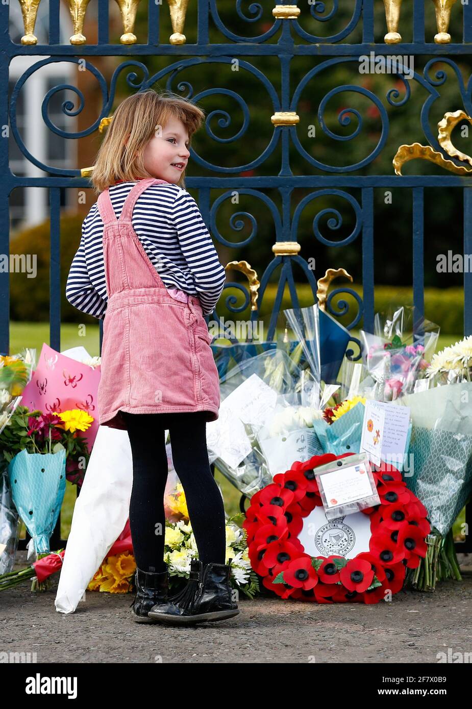 Ein Mädchen steht vor Blumen, die im Hillsborough Castle aufgestellt wurden, nachdem der britische Prinz Philip, Ehemann von Queen Elizabeth, am 10. April 2021 im Alter von 99 Jahren in Hillsborough, Nordirland, starb. REUTERS/Jason Cairnduff Stockfoto