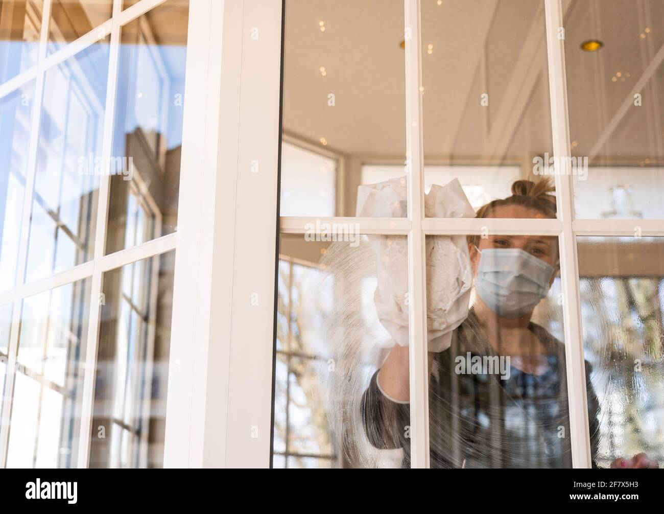 Kiel, Deutschland. April 2021. Ein Mitarbeiter des Cafés 'Wichtig' putzt die Fenster zur Außenterrasse. In Schleswig-Holstein wird eine mögliche Eröffnung der Outdoor-Gastronomie vorbereitet. Quelle: Axel Heimken/dpa/Alamy Live News Stockfoto