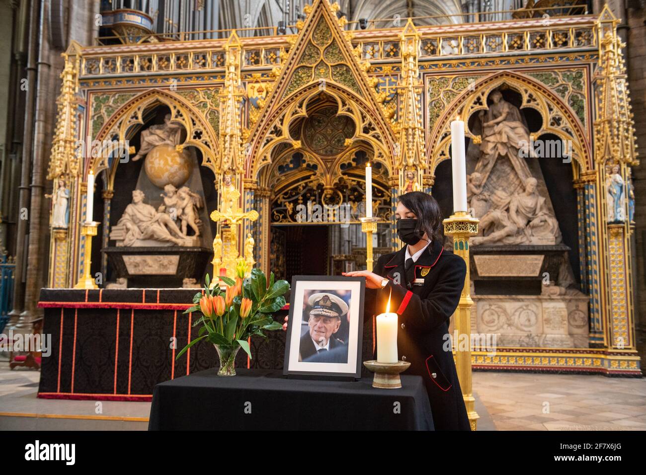 Rosa Wlodarczyk passt ein Foto des Herzogs von Edinburgh an, das neben dem Kirchenschiff in der Westminster Abbey, London, ausgestellt ist und aus Anlass seines Todes schwarz gekleidet wurde. Bilddatum: Samstag, 10. April 2021. Stockfoto