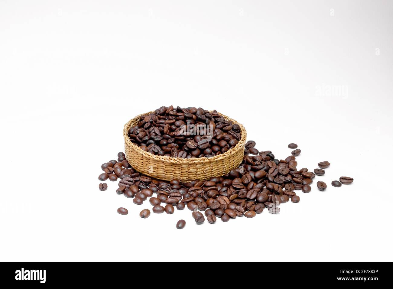 Schwarzer Kaffee in Bohnen in geflochtenen Gerichten auf einem weißen Hintergrund Stockfoto