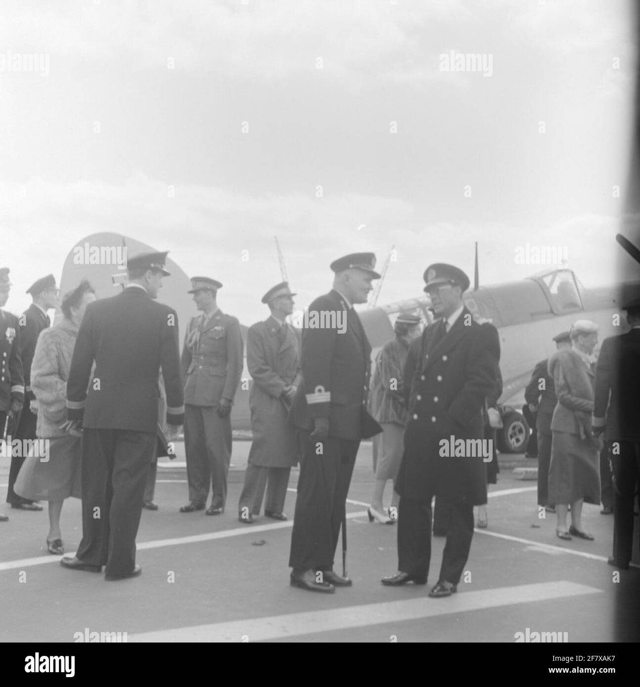 Fotoment des Staatsbesuchs des dänischen Königspaares, König Frederik IX. Und Königin Ingrid, in den Niederlanden. Die königliche Gesellschaft und ihre Courtège versammeln sich am Flugzeuglift auf dem Flugdeck von HR. Frau Karel Doorman (1948-1968). Ist Teil der Objektserie AVDKM 540154 bis 540167. Stockfoto