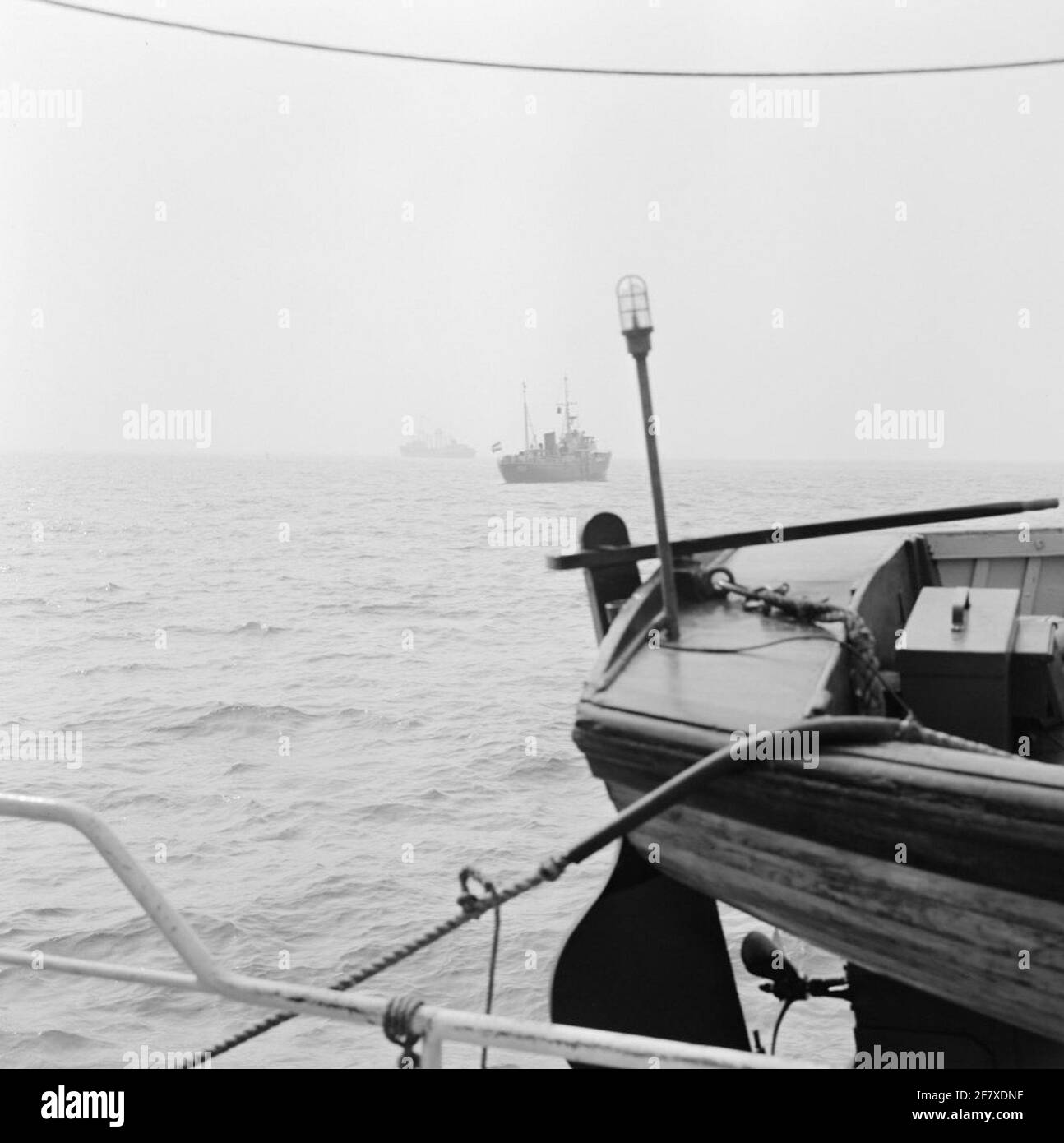 Die Steuern für Seeschiffe werden durch die Lotsendienste des Verteidigungsministeriums (Marine) erhoben. In der Ferne forquiert das Lotsenboot, genauso wie die Sirius ein Schiff aus der Lotse Hoek van Holland. Stockfoto
