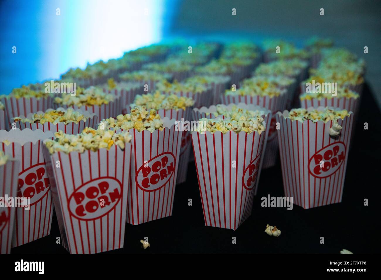 Rote und weiße Papiertüten, mit denen kein Tisch gefüllt ist Gelb-weißer Popcorn bei einem Filmabend mit Freunde Stockfoto