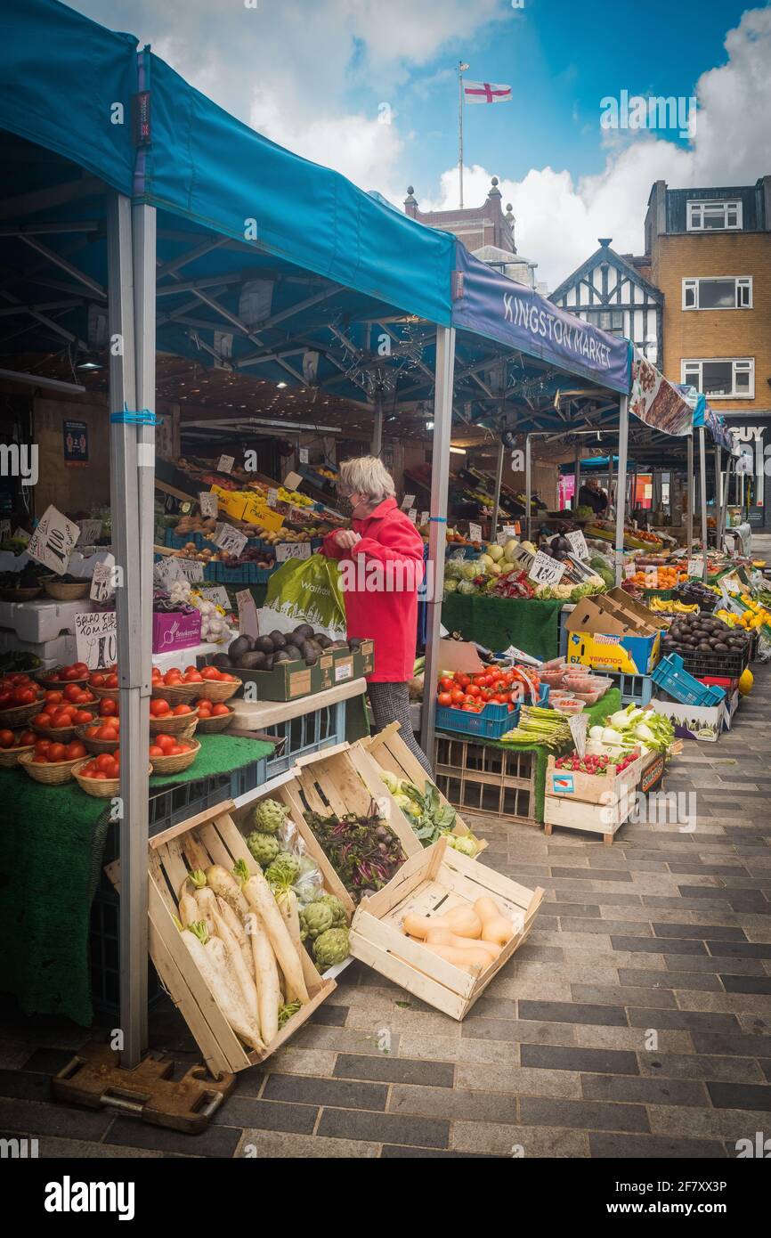Alte Frau, die am Obst- und Gemüsestand in Kingston Market, London, Großbritannien, einkauft Stockfoto