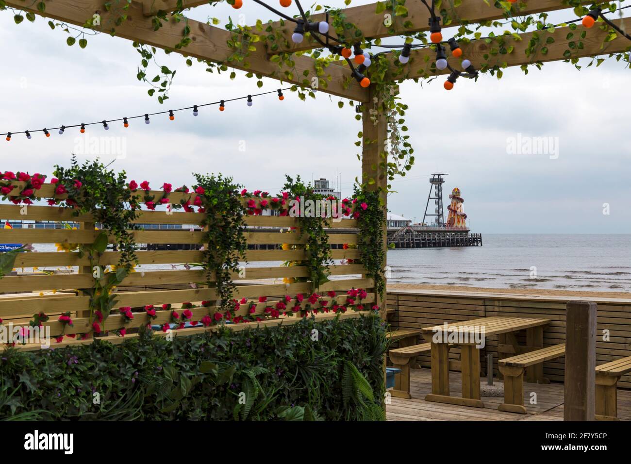 Westbeach bietet im April einen Essbereich im Freien mit Blick auf den Strand, das Meer und den Pier in Bournemouth, Dorset, Großbritannien Stockfoto