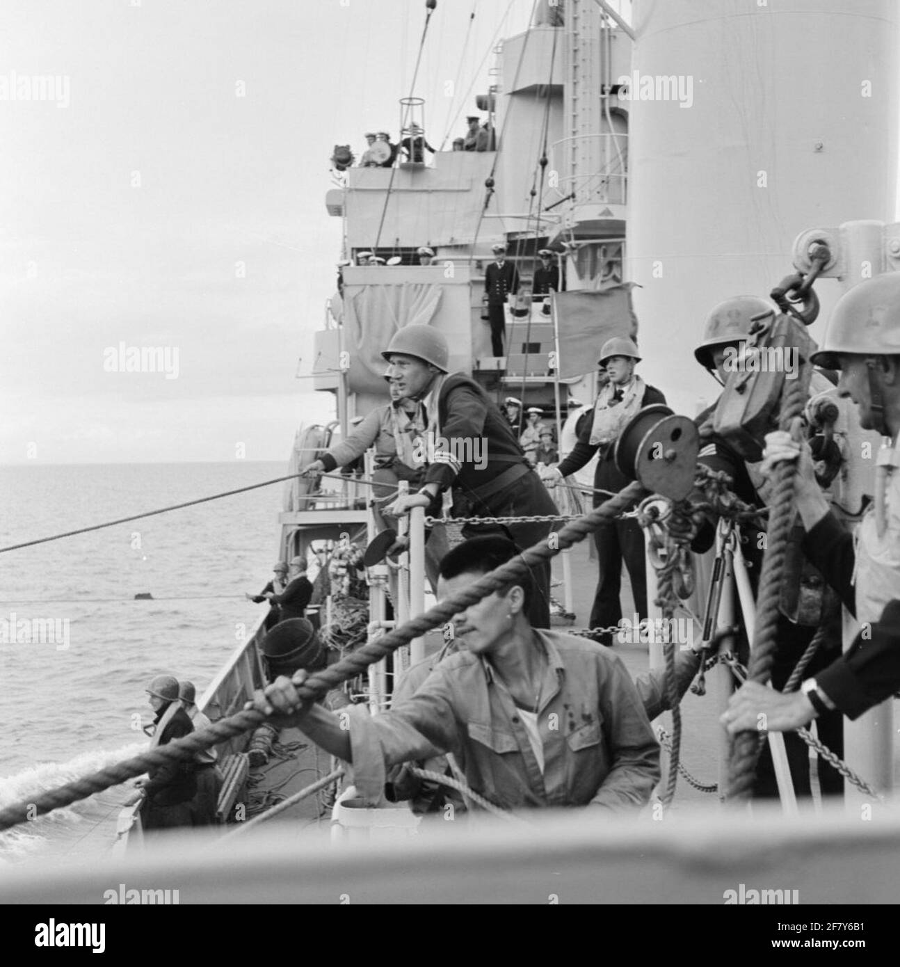 An Bord HR.Ms. De Zeeuw (F 810) (1951-1964) (EX-USS Eisner: DE-192), eine Fregatte der Van Amstel-Klasse, bringt die jüngsten Menschen, die auch zur sogenannten "Schifffahrt" genannt werden, um die notwendige See-Erfahrung zu sammeln. Die Abgabe von leichten Lasten muss geübt werden. Stockfoto