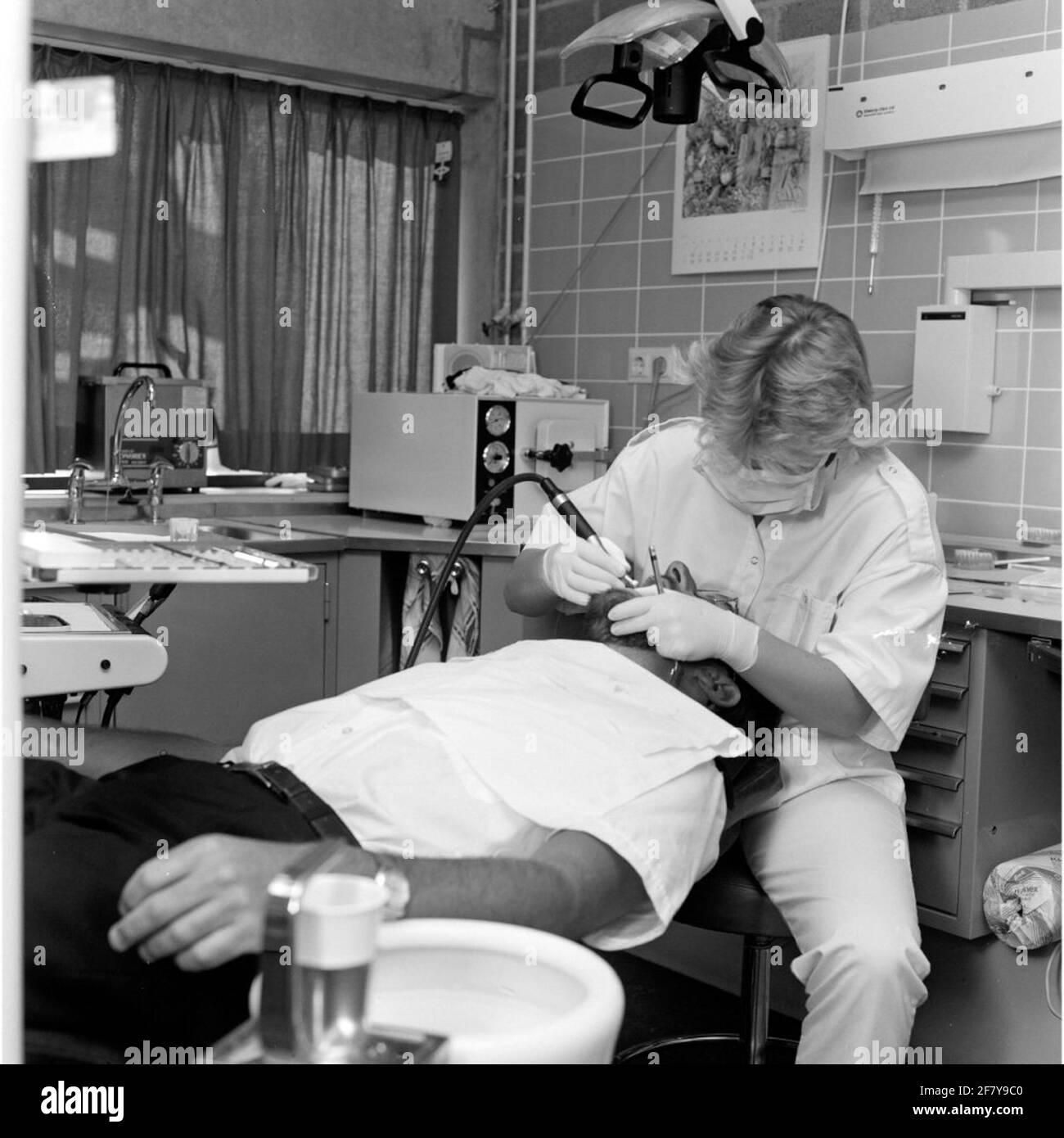 Ein Zahnarzt der Zentralkrankheit (CZB) in der Marine Barracks Willemsoord (MKWD) in Den Helder untersucht die Zähne eines Patienten (Juli 1989). Stockfoto