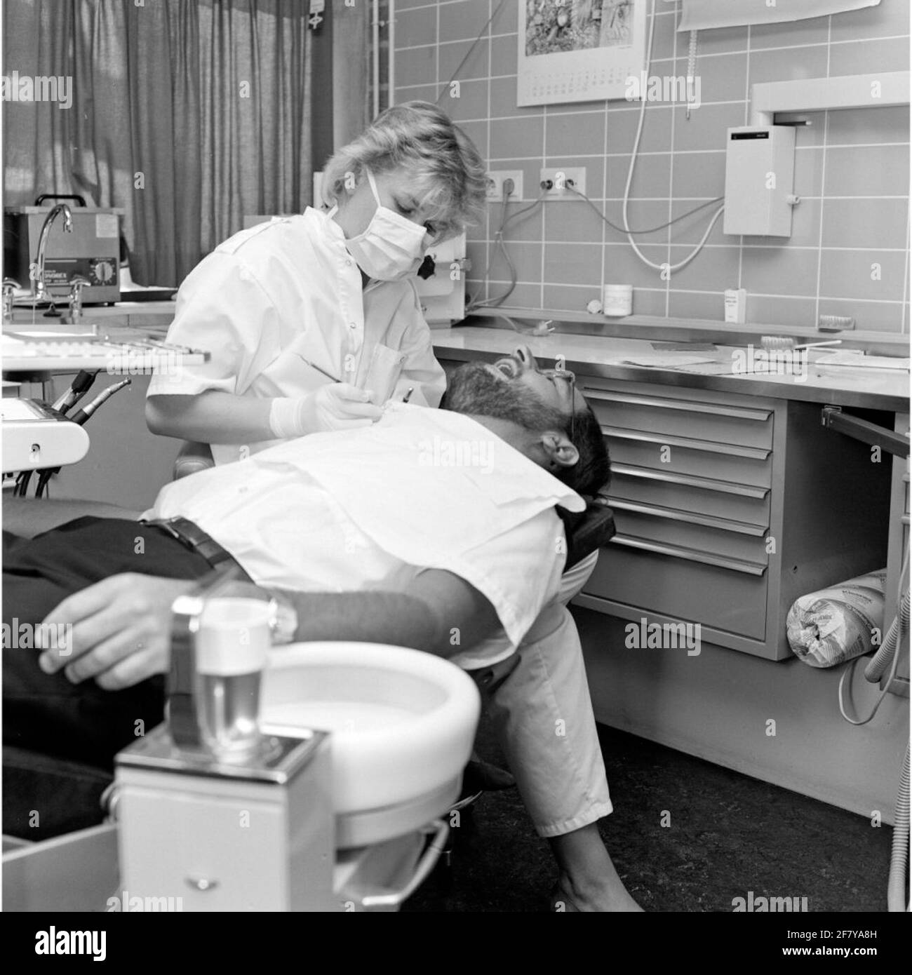 Ein Zahnarzt der Zentralkrankheit (CZB) in der Marine Barracks Willemsoord (MKWD) in Den Helder untersucht die Zähne eines Patienten (Juli 1989). Stockfoto