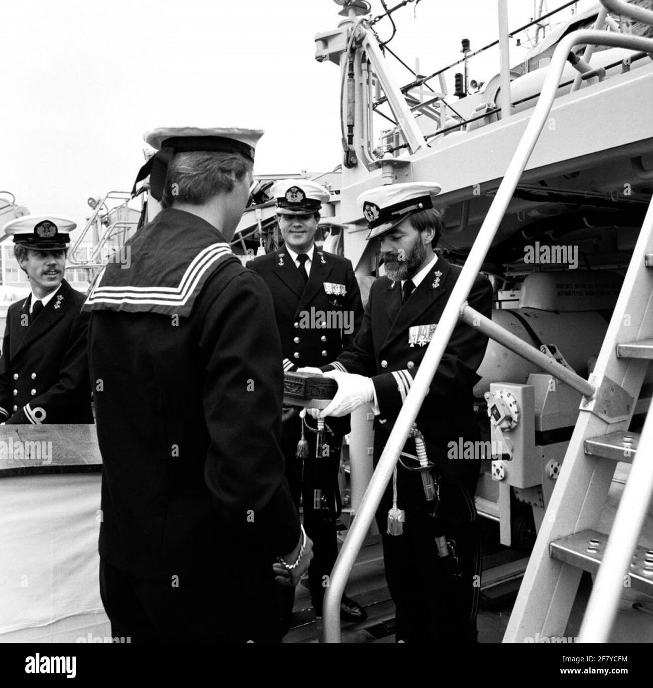 Kommandotransfer an Bord der Alkmaar-Klasse dreigliedrigen Mine Jäger, HR.Ms. Harlingen (1984-2003). Leutnant auf dem Meer von ​​special Dienstleistungen der 1. Klasse (LTZSD 1) J.O. Geertsma übergibt das Kommando an Leutnant auf See von ​​special-Diensten der 1. Klasse (LTZSD 1) J.G. Fuchs. Ltzsd 1 J. O. Geertsma erhält die Kiste mit dem Kriegswinker vom jüngsten Seemann. Stockfoto