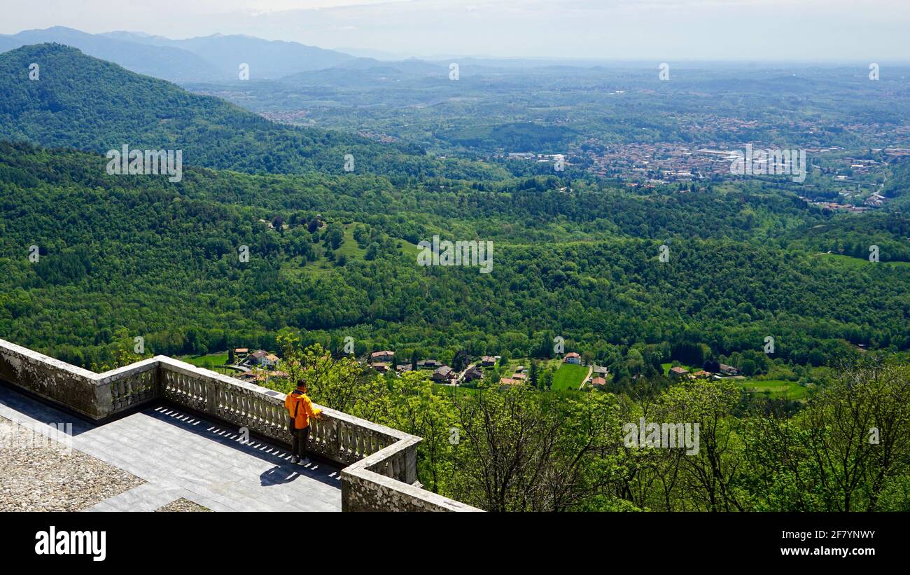 Ein Mann, der auf Beobachtung steht, um die grünen Berge und das Tal zu beobachten. Stockfoto