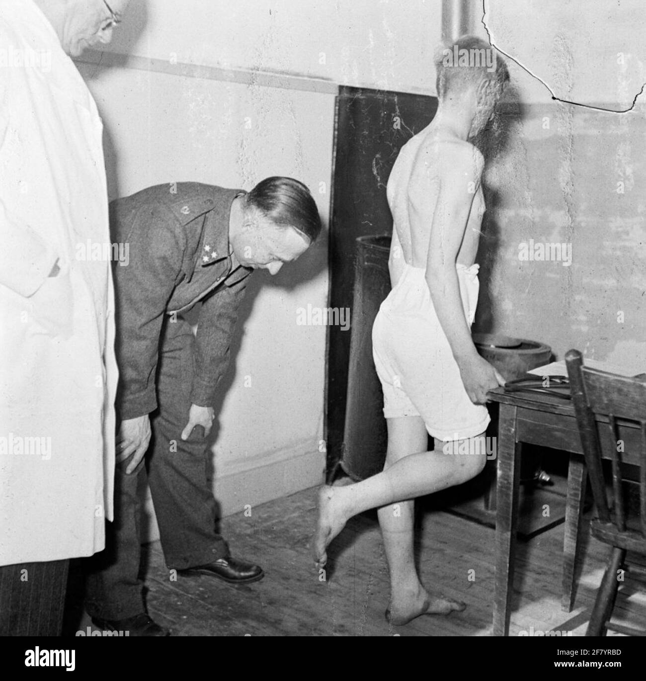 Ein Hauptmann des medizinischen Dienstes schaut auf die Fußsohle eines Elternteils. Stockfoto