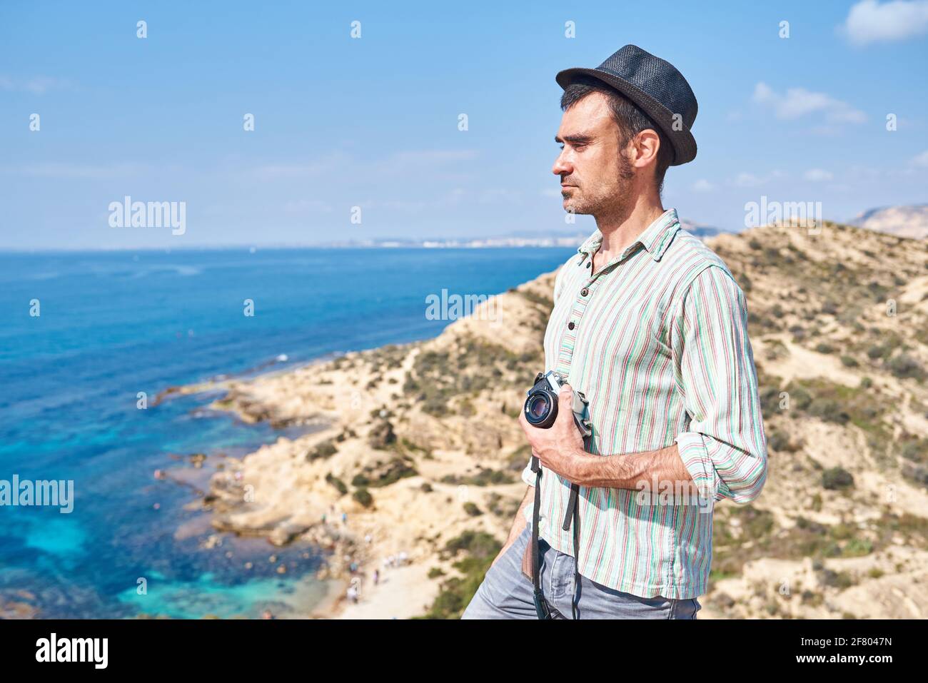 Ein junger Reisender, der in einem Touristengebiet steht, wo Sie Kann schöne Farben des Meeres und des Strandes sehen Stockfoto