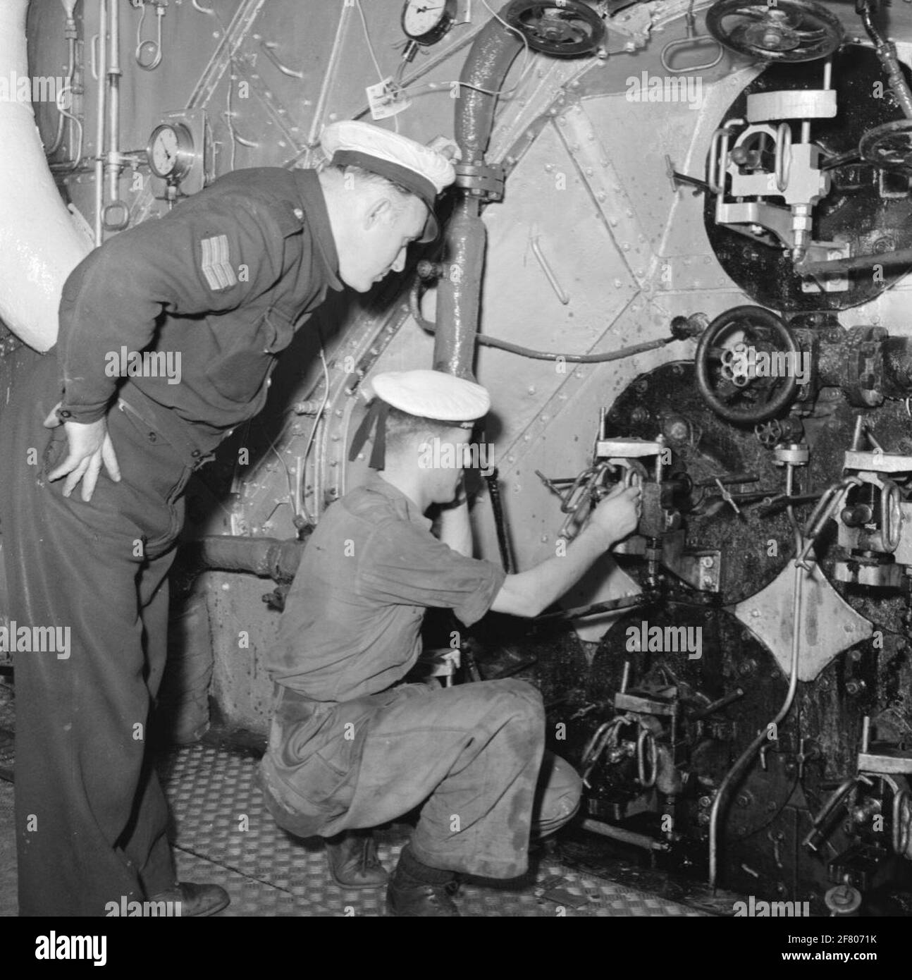 Funktionsbericht an Bord der Personalabteilung erstellt. Frau Tromp (1948-1954). Unter der Aufsicht eines Sergeant-Fahrers stellt der Betreiber einen Brenner in einen Kessel. Ist Teil der Objektserie AVDKM 530024 bis 530050. Stockfoto