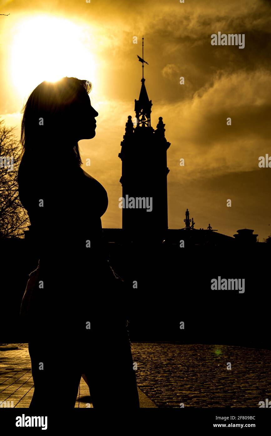 Aufnahme der Silhouette einer Spanierin im Profil Mit einem Turm hinter ihr während des Sonnenuntergangs Stockfoto
