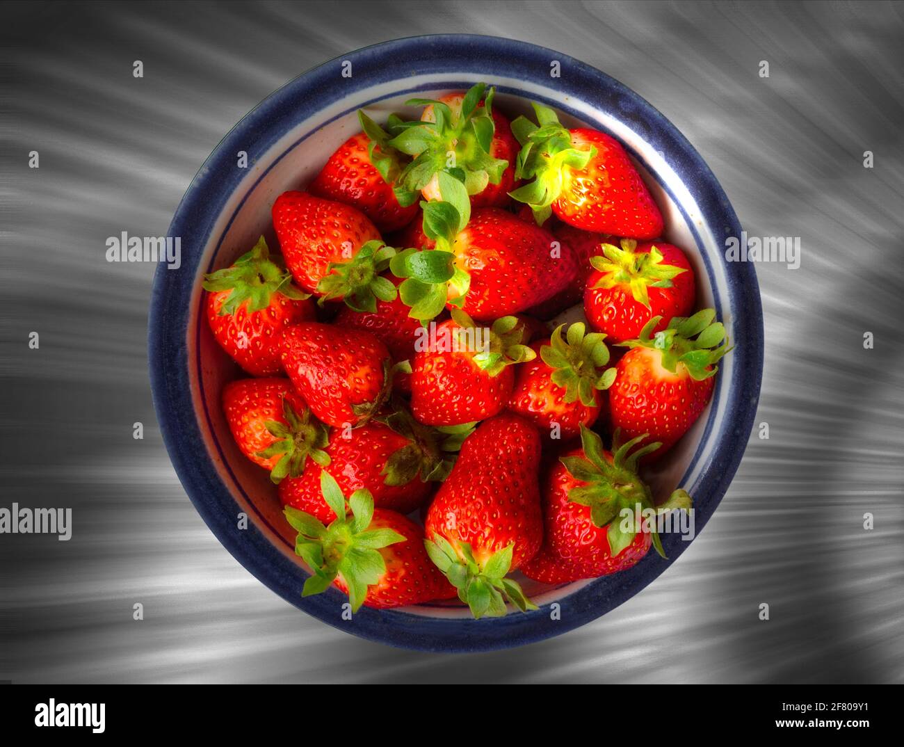 ERNÄHRUNGSKONZEPT: Frische Erdbeeren in blau umrandter Keramik Stockfoto