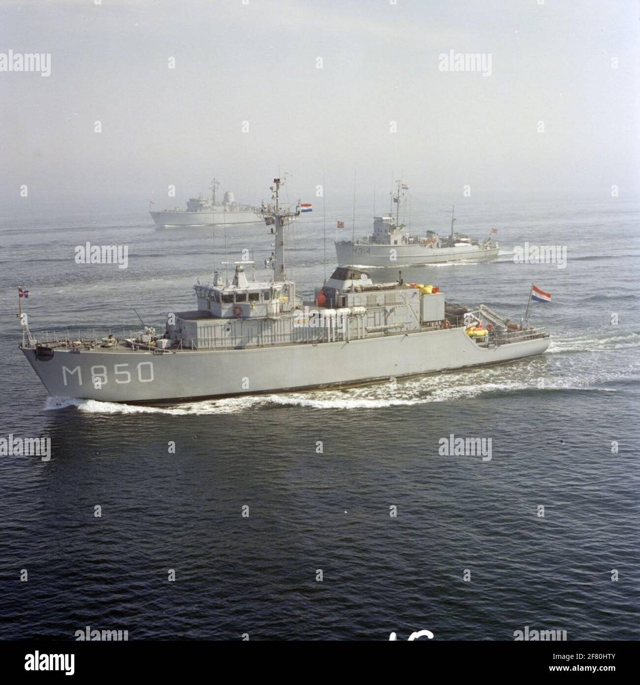 Luftaufnahme von Schiffen der NATO StanavForchan (Standing Naval Force in the Channel), einschließlich der Kehrmaschinen/Jäger niederländischer Minen im Mai 1989. Im Vordergrund der Minenjäger HR.Ms. Alkmaar (M 850, 1983-2000) und dahinter der Norweger Mijnenveger KNM Alta (M 314, 1954). Komplett hinter dem britischen Bergwerksjäger HMS Dulverton (M 35, 1983) aus der 'Hunt'-Klasse. Stockfoto