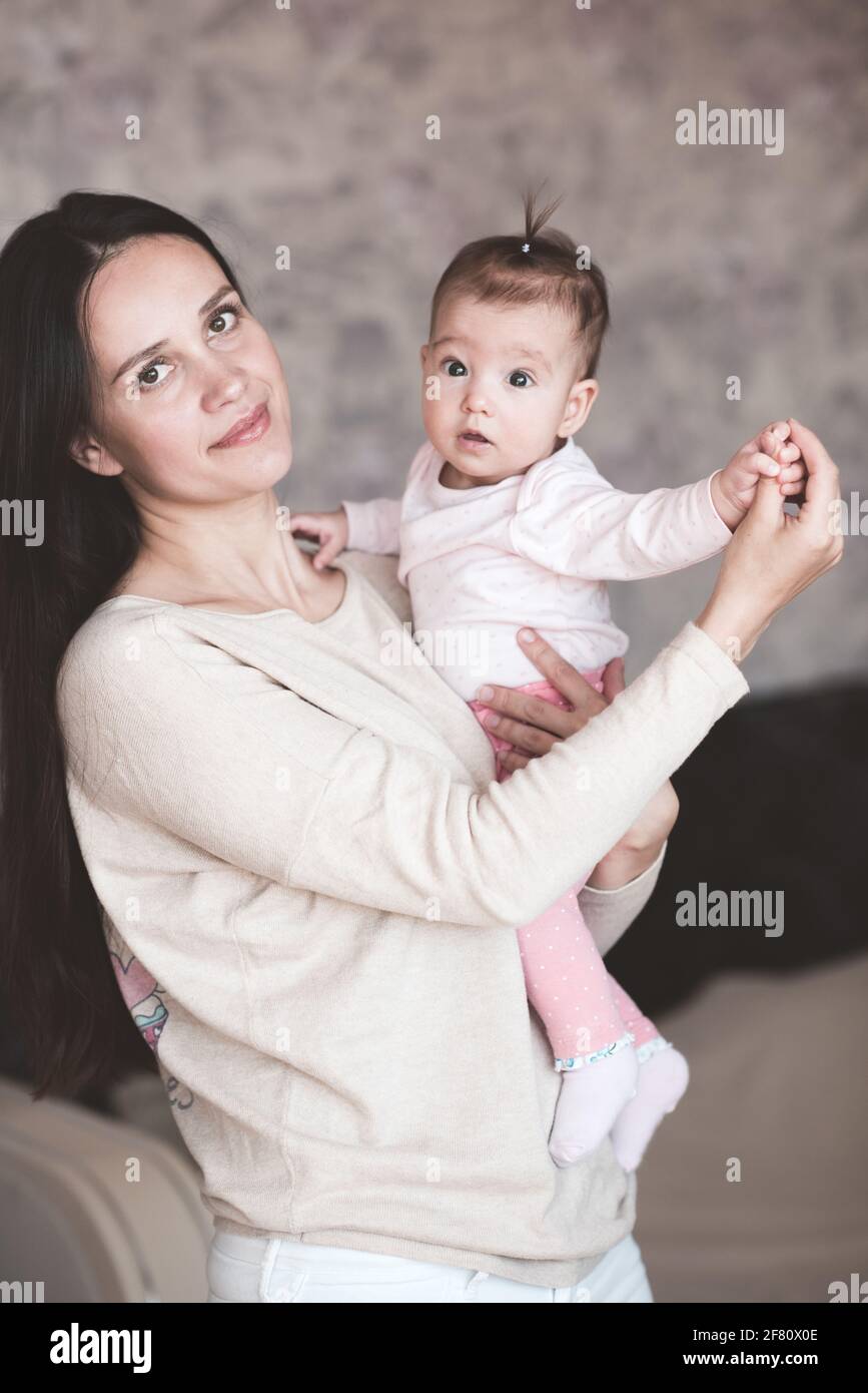 Mutter hält Baby Mädchen zu Hause. Neugeborenes Kind auf weiblichen Händen im Haus. Mutterschaft. Mutterschaft. Stockfoto