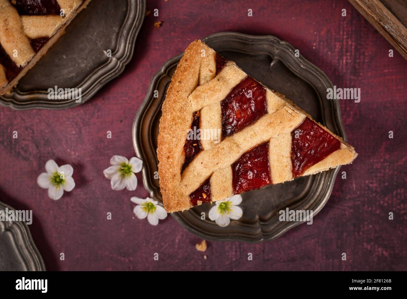 Ein Stück Kuchen namens „Linzer Torte“, ein traditionelles österreichisches Gebäck mit Obstkonserven und in Scheiben geschnittenen Nüssen im Gitterdesign Stockfoto