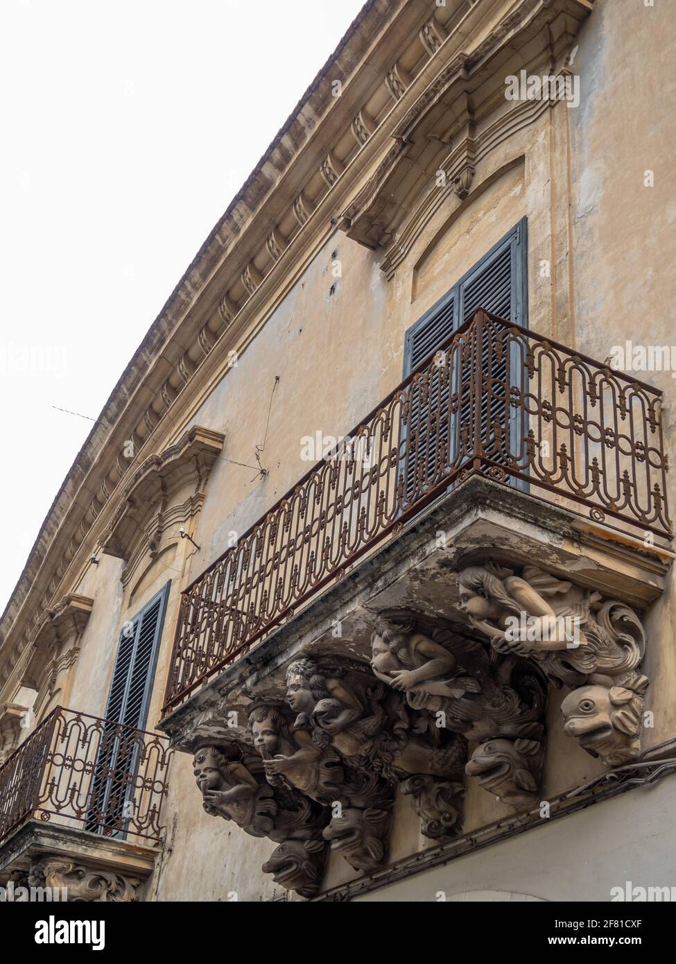 Palazzo Tommasi Rosso Tedeschi Balkon unterstützt von grotesken Figuren, Modica Stockfoto