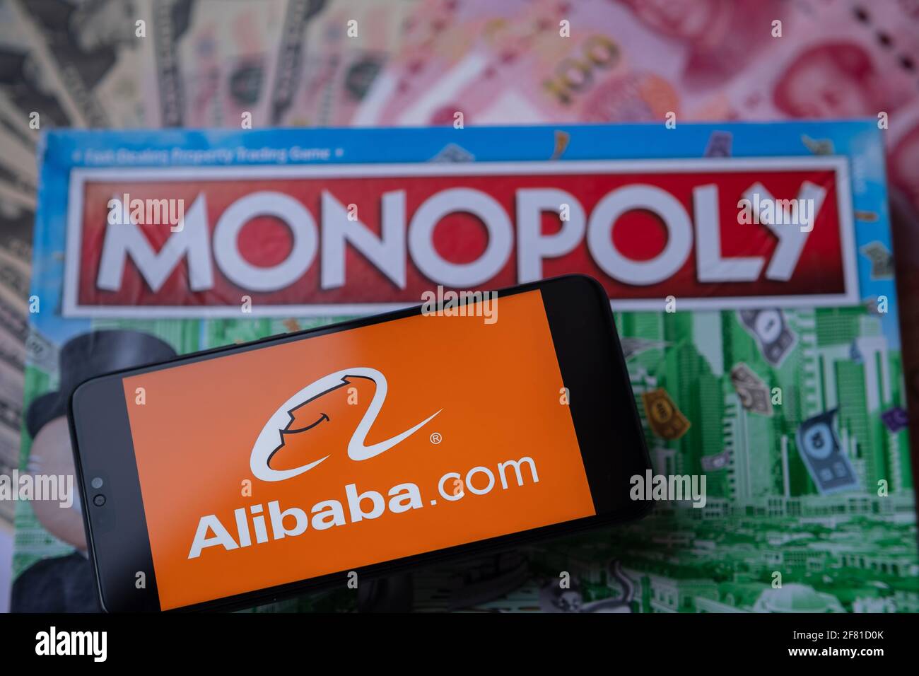 Alibaba-Logo auf dem Smartphone, das auf Monopoly Spiel platziert wird gesehen. Selektiver Fokus. Unscharfer Hintergrund. Konzept. Staffrod, Großbritannien, 10. April 20 Stockfoto