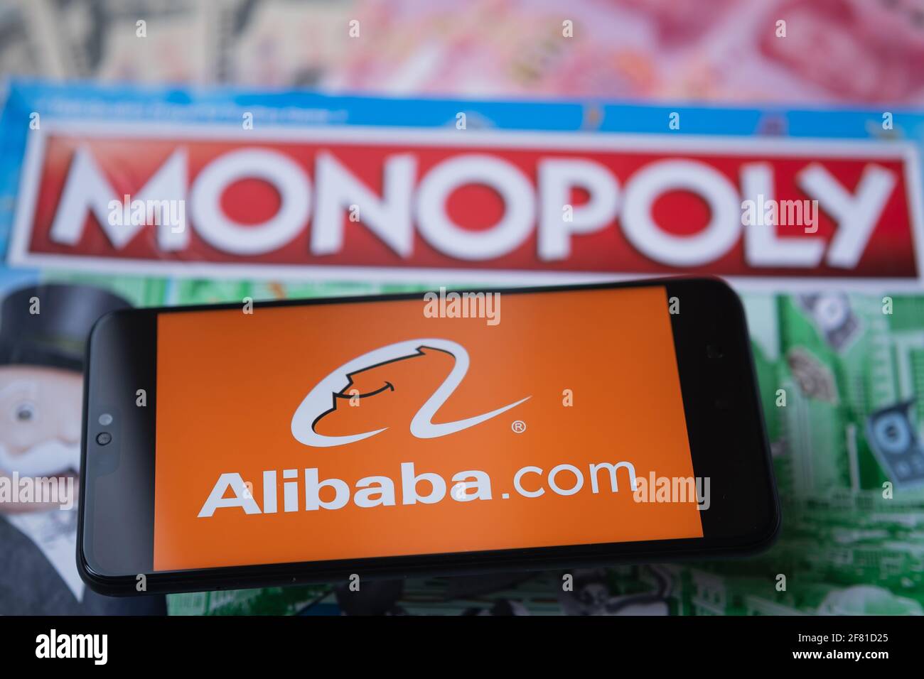 Alibaba-Logo auf dem Smartphone, das auf Monopoly Spiel platziert wird gesehen. Selektiver Fokus. Unscharfer Hintergrund. Konzept. Staffrod, Großbritannien, 10. April 20 Stockfoto