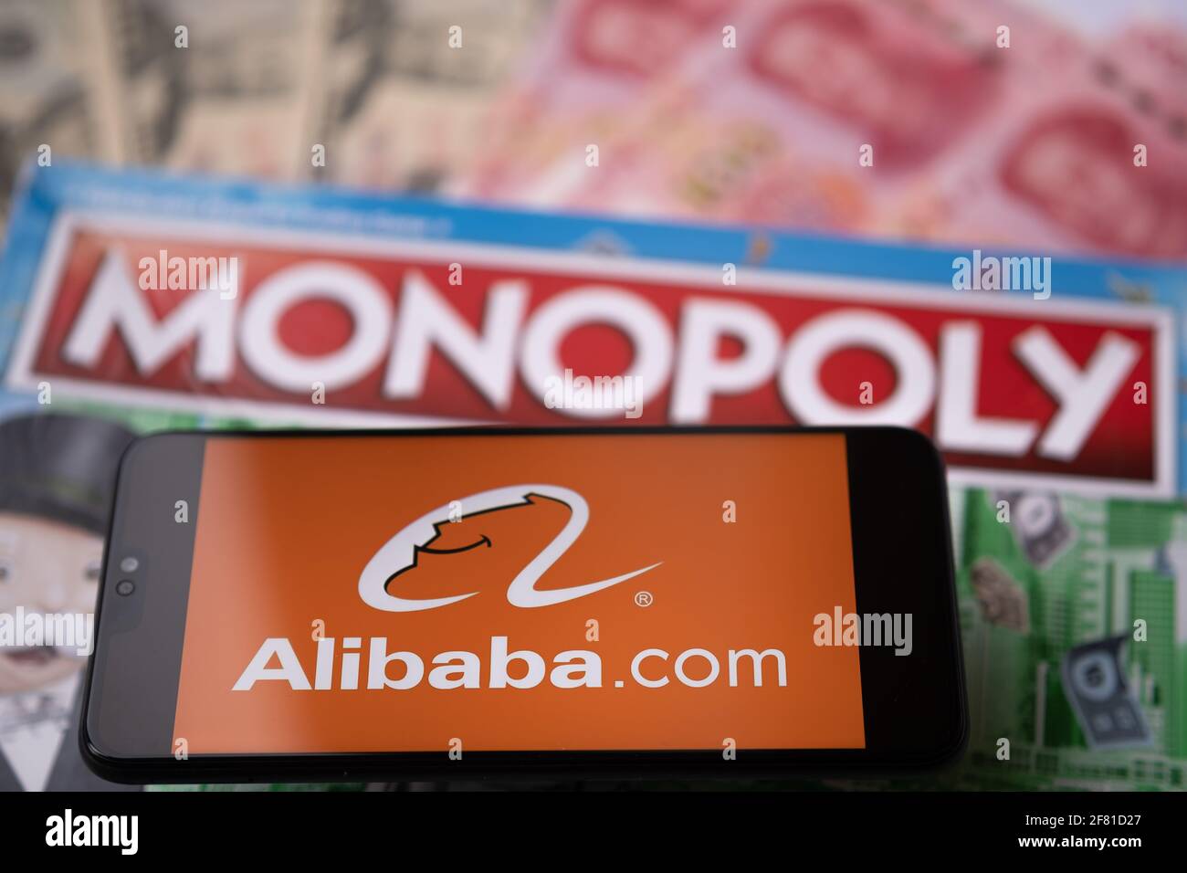 Alibaba-Logo auf dem Smartphone, das auf Monopoly Spiel platziert wird gesehen. Selektiver Fokus. Unscharfer Hintergrund. Konzept. Staffrod, Großbritannien, 10. April 20 Stockfoto