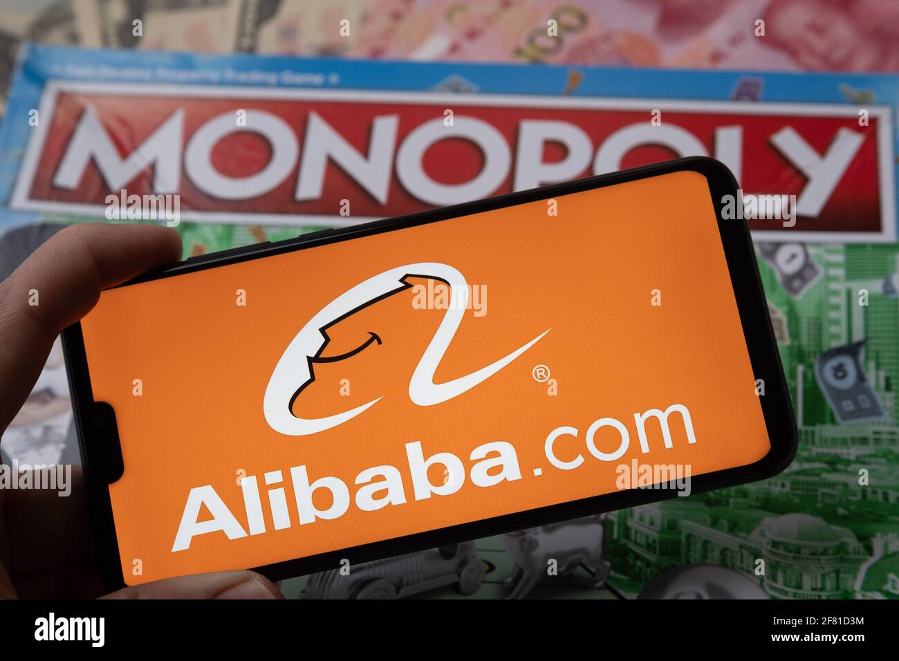 Alibaba-Logo auf dem Smartphone, das auf Monopoly Spiel platziert wird gesehen. Selektiver Fokus. Unscharfer Hintergrund. Konzept. Staffrod, Großbritannien, 10. April 20 Stockfoto