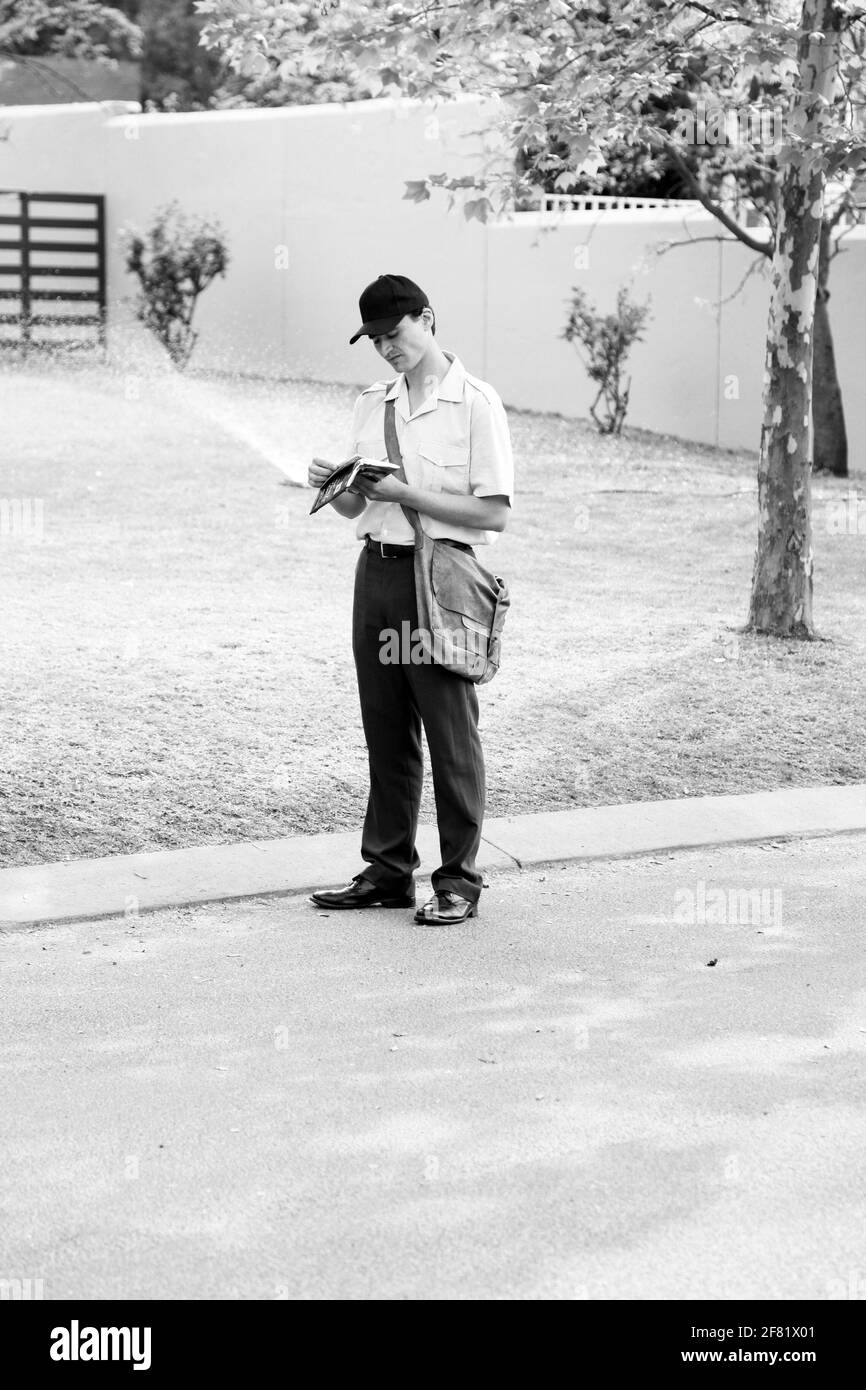 JOHANNESBURG, SÜDAFRIKA - 13. Mär 2021: Johannesburg, Südafrika - 11. September 2010: Post Mailman Hand liefert Post in einem wohlhabenden Vorort Stockfoto
