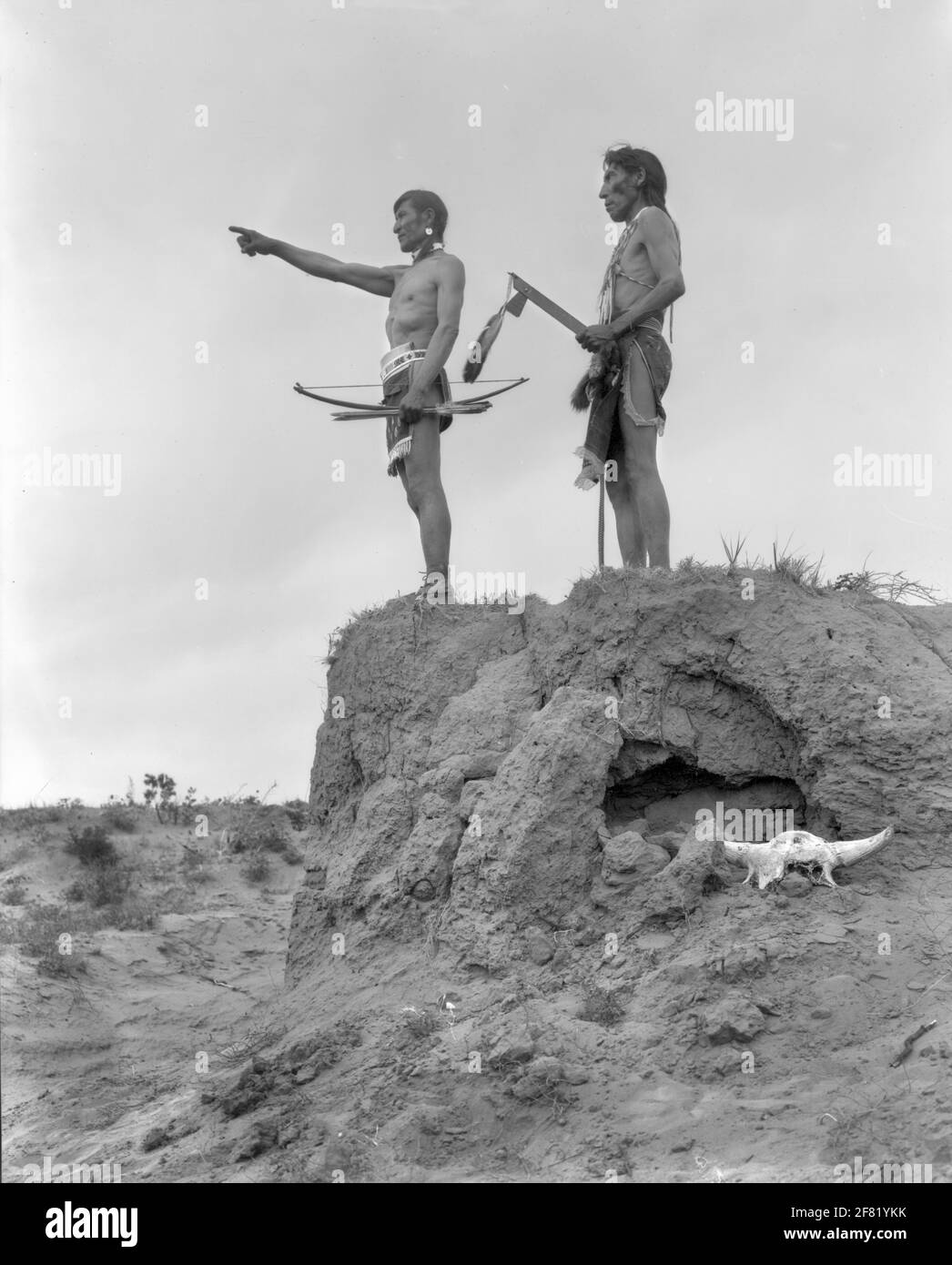 Portrait of Black Kettle (links) und Many Shot (rechts). Zwei halbbekleidete Männer betrachten die Landschaft mit Tomahawk und Pfeil und Bogen in der Hand. Stockfoto