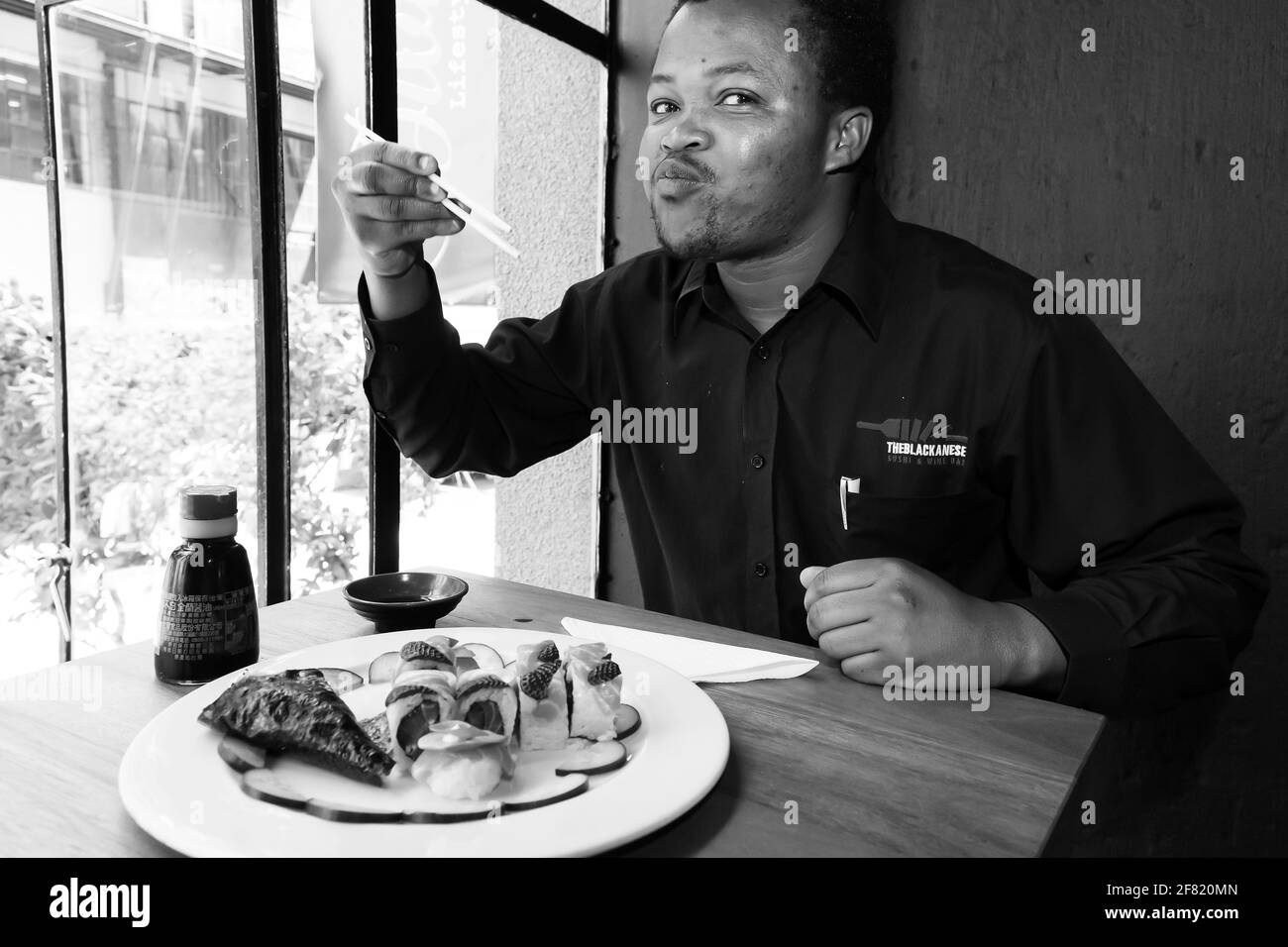 JOHANNESBURG, SÜDAFRIKA - 13. März 2021: Johannesburg, Südafrika - 28 2014. September: Afrikanischer Mann beim Sushi-Essen in einem Restaurant Stockfoto