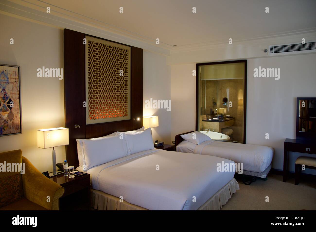 DUBAI, VEREINIGTE ARABISCHE EMIRATE - JUN 16, 2019: Luxus-Hotelzimmer mit Bett und Blick im Badezimmer mit schöner Dekoration Stockfoto