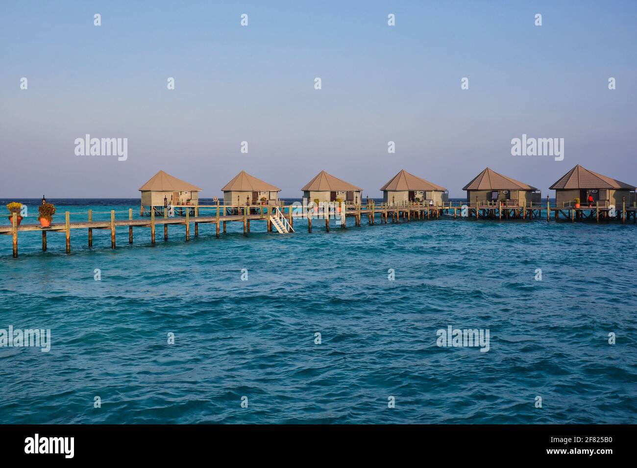 Golden Hour Blick auf Water Villas auf den Malediven. Überwasser-Bungalow, hölzerner Pier und Laccadive Meer im maledivischen Resort. Stockfoto