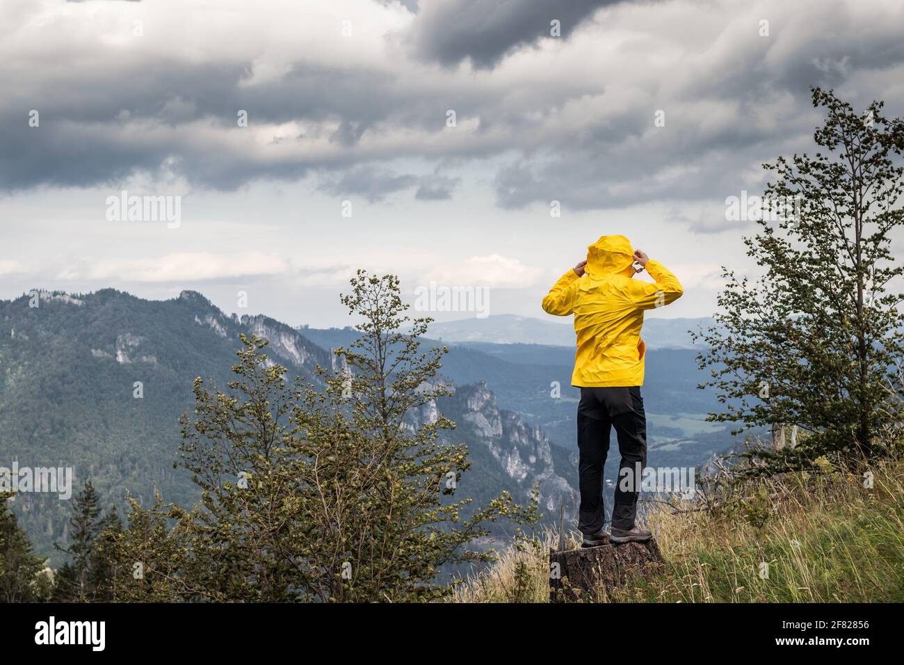 Starker Wind in den Bergen. Frau in Sportkleidung beim Wandern in der Wildnis. Das Wetter in den Bergen verändert sich rasant Stockfoto