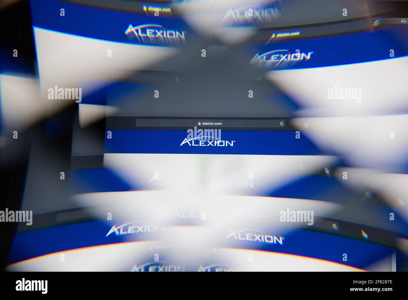 Mailand, Italien - 10. APRIL 2021: Alexion Pharmaceuticals-Logo auf dem Laptop-Bildschirm durch ein optisches Prisma gesehen, kreative Interpretation. Dynamisch und einzigartig Stockfoto